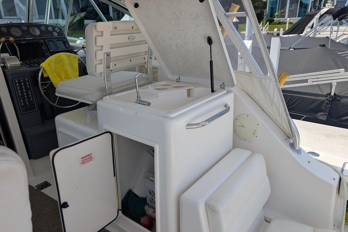 2000 Pursuit 3400 Express boat interior with helm, seating, and sink area.