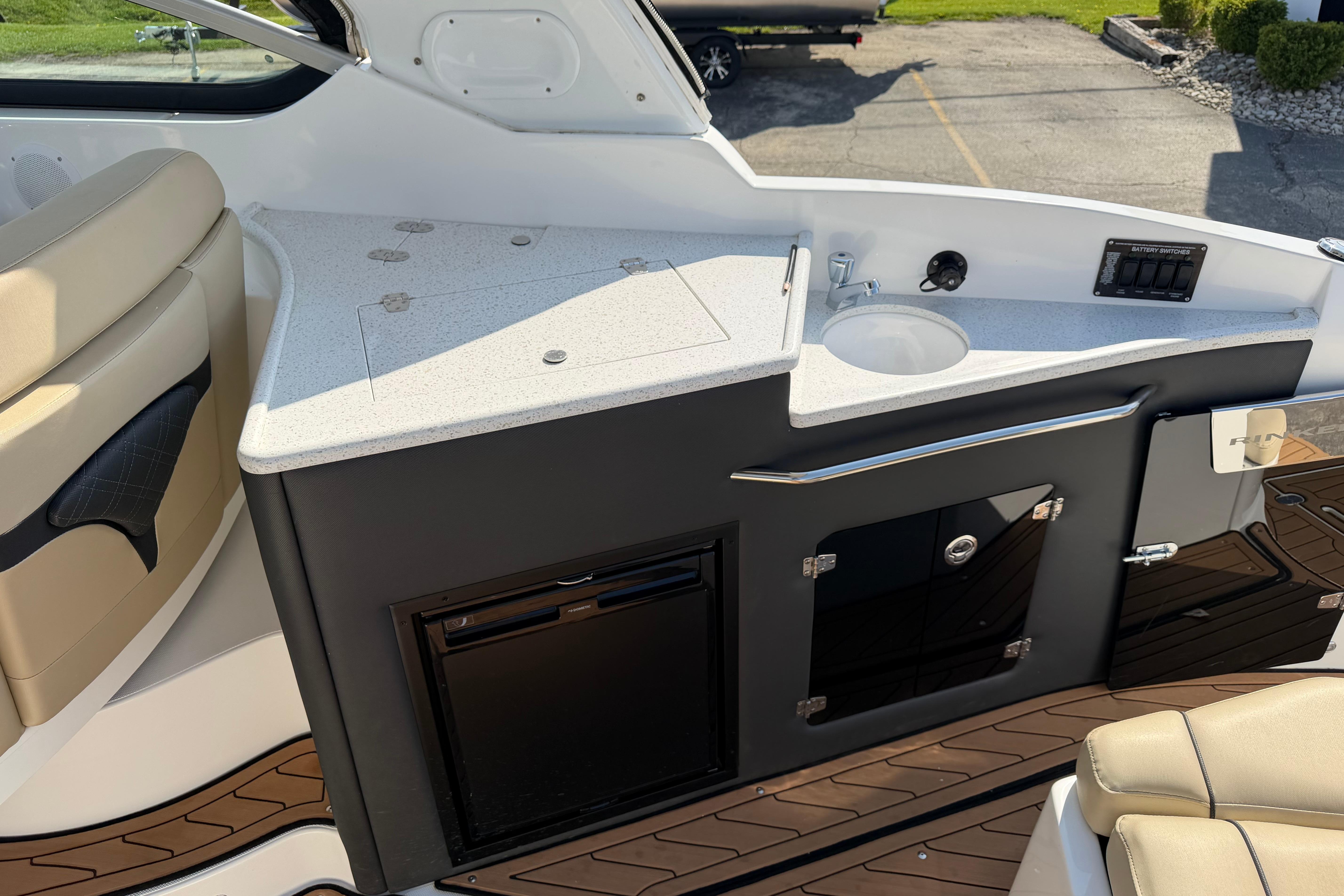2019 Rinker EX 320 boat interior with kitchenette and seating area.