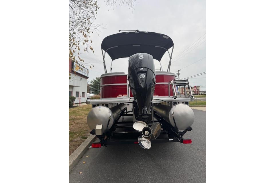 2026 Sun Tracker Party Barge 22 DLX pontoon boat with outboard motor, rear view.