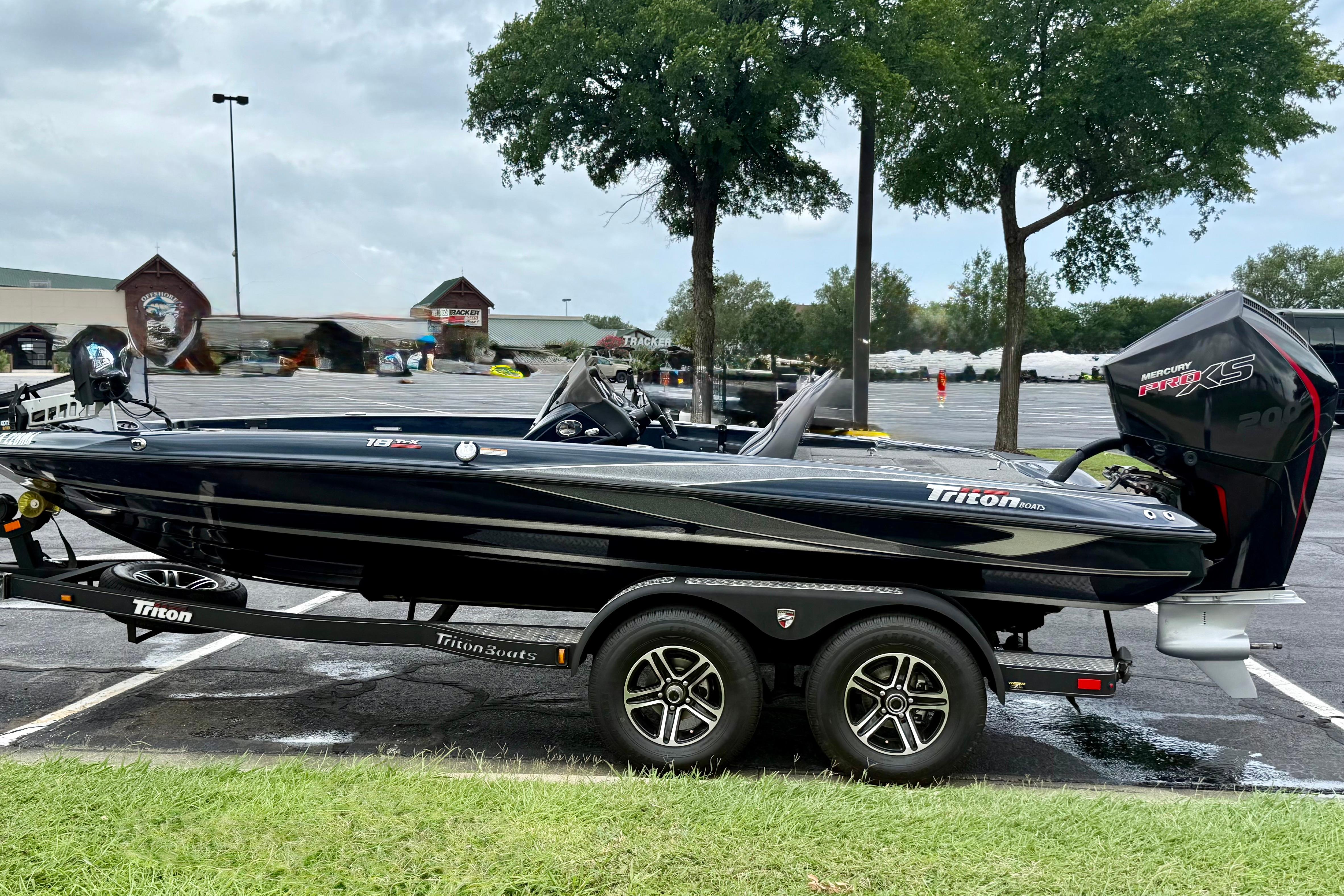 2023 Triton 18 TrX boat on trailer in parking lot, featuring sleek design and Mercury Pro XS engine.