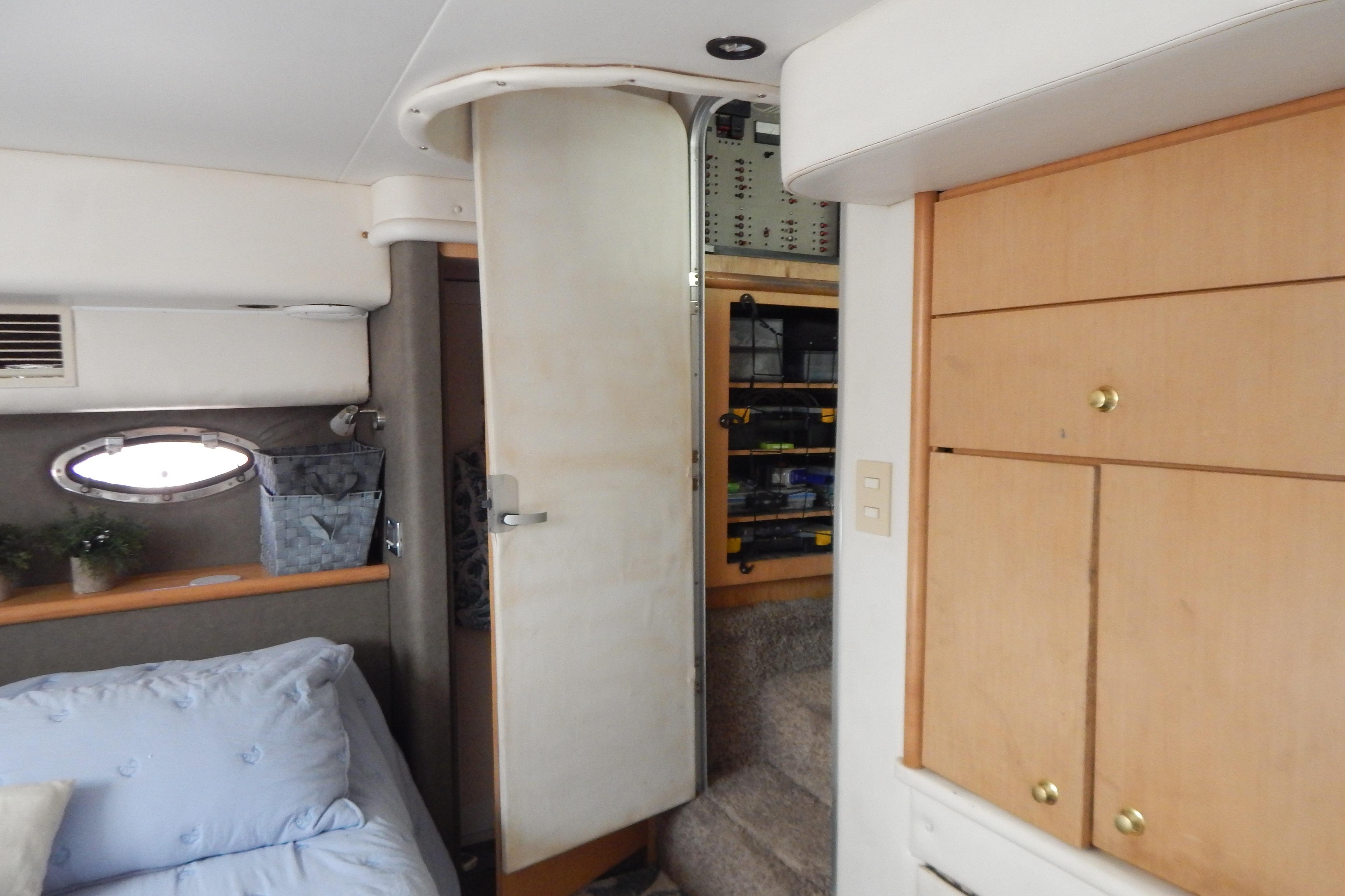 Interior of a 1998 Magnum 4100 SCR yacht with wooden cabinets and cozy bedding.