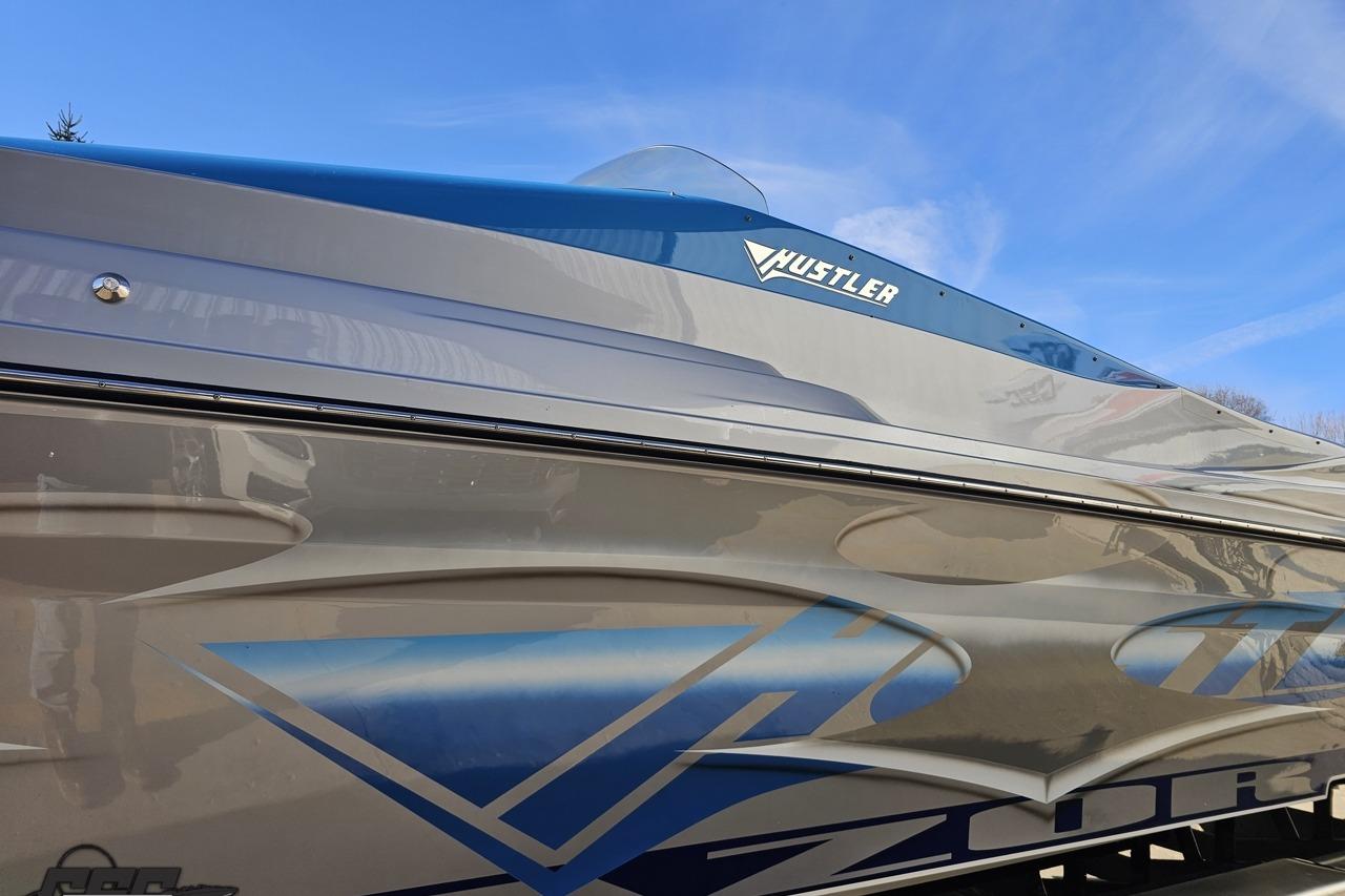 2007 Hustler 41 Razor boat with sleek design and blue accents under clear sky.