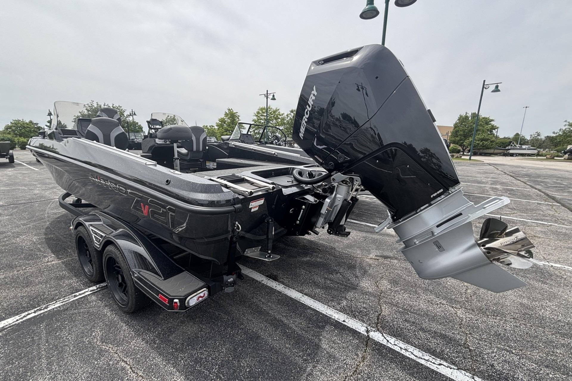 2026 Nitro ZV21 boat with Mercury outboard engine in parking lot.