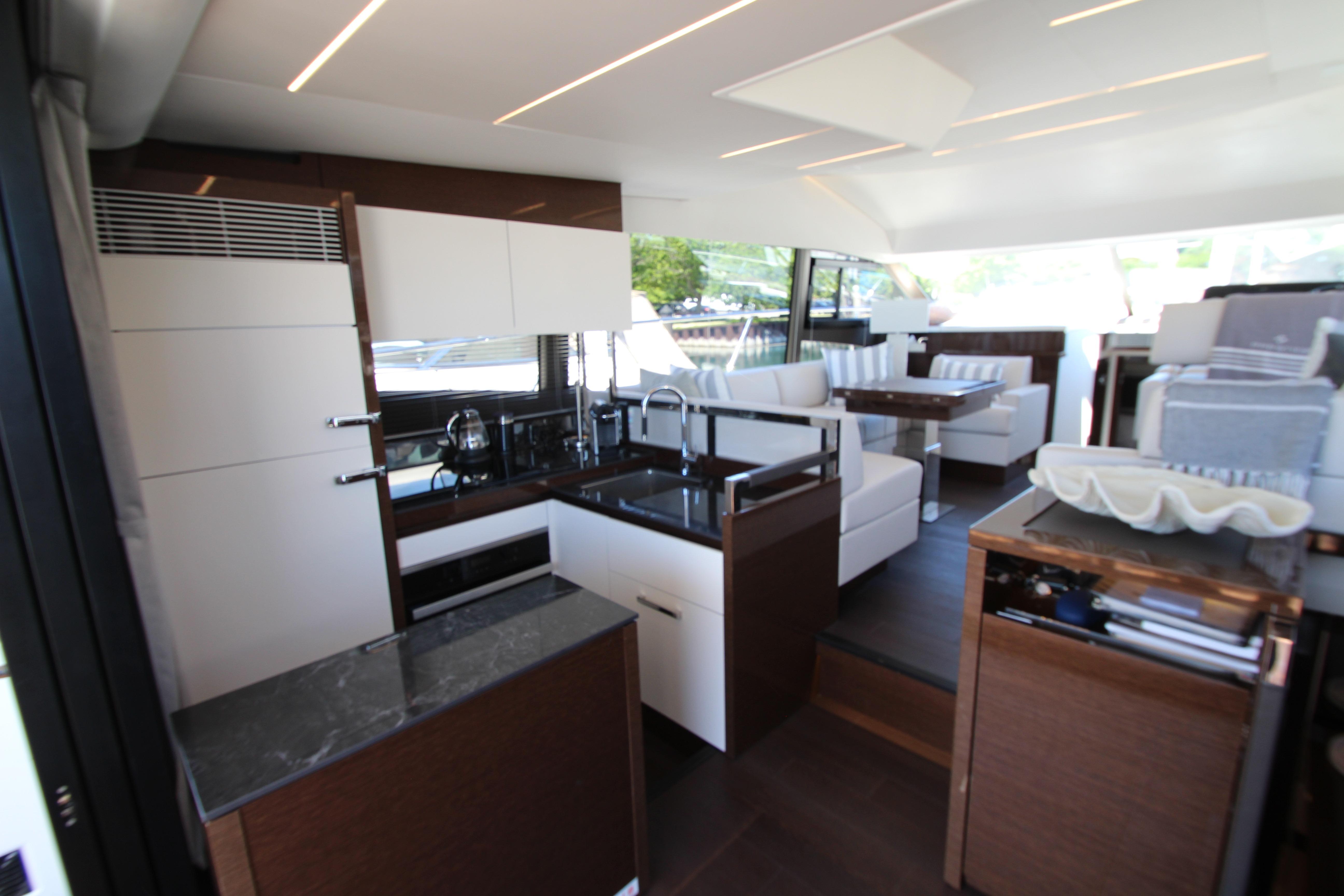 Modern interior of 2022 Prestige 520 yacht with sleek kitchen and comfortable seating area.
