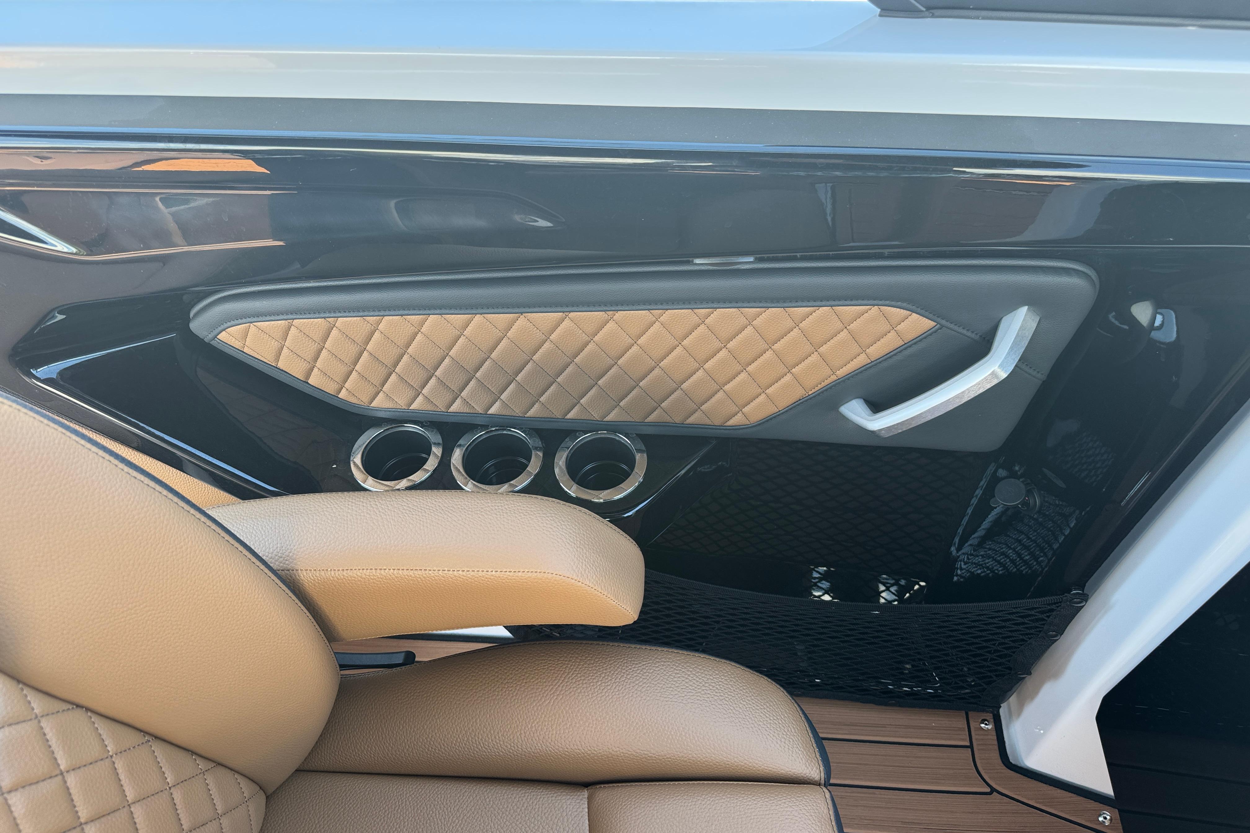 Luxurious interior of 2026 Yamaha Boats 252SD with quilted leather and cup holders.