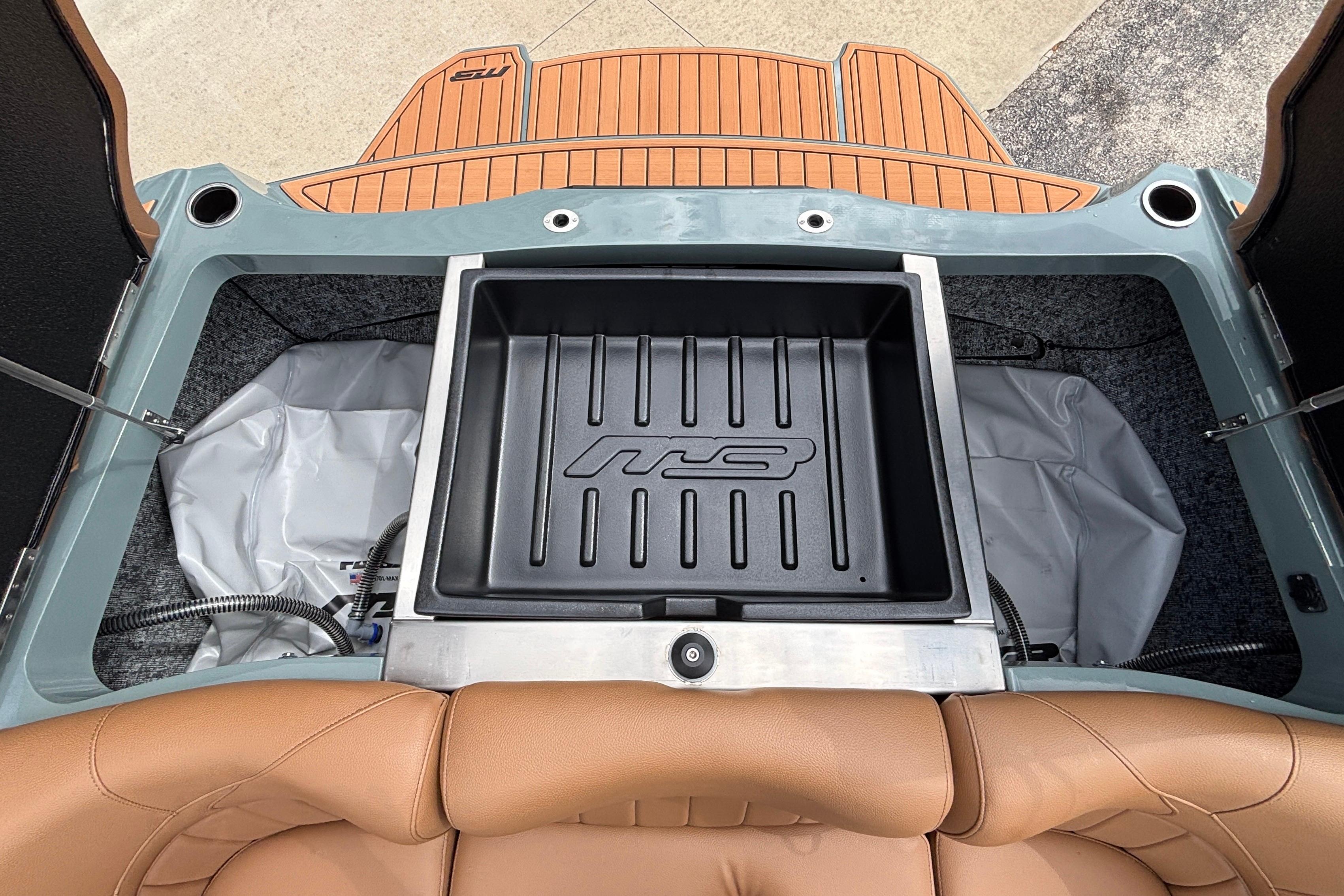 2026 MB B52 23 Classic boat interior with storage compartment and tan seating.