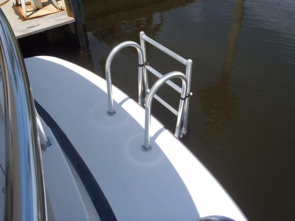 Stainless steel swim ladder on 2025 Great Harbour N40 boat, docked in calm water.