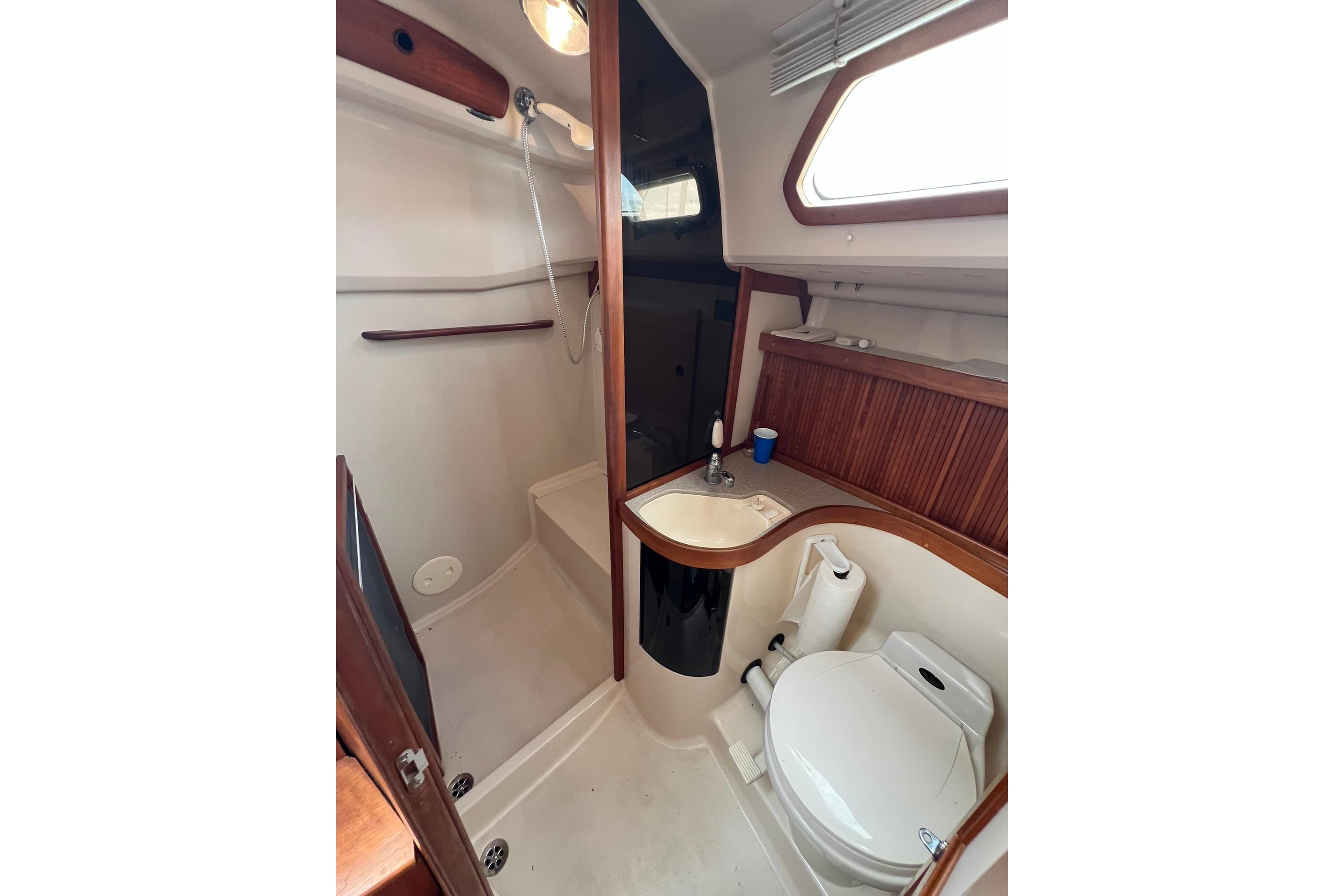 Bathroom interior of 1998 Sabre 362 yacht, featuring shower, sink, and toilet.