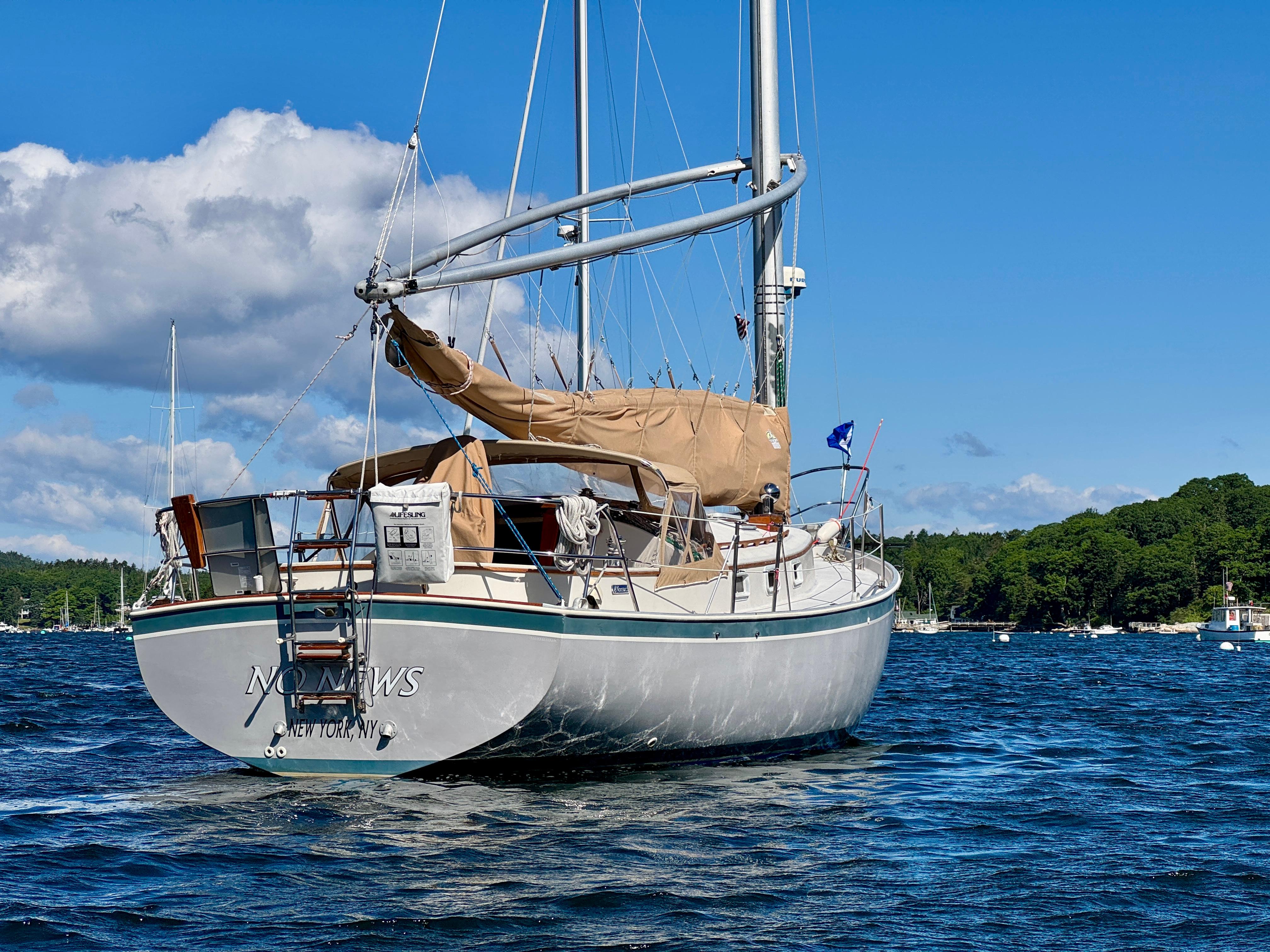 1989 Nonsuch 30 Ultra sailboat on a sunny day, anchored in a scenic bay.