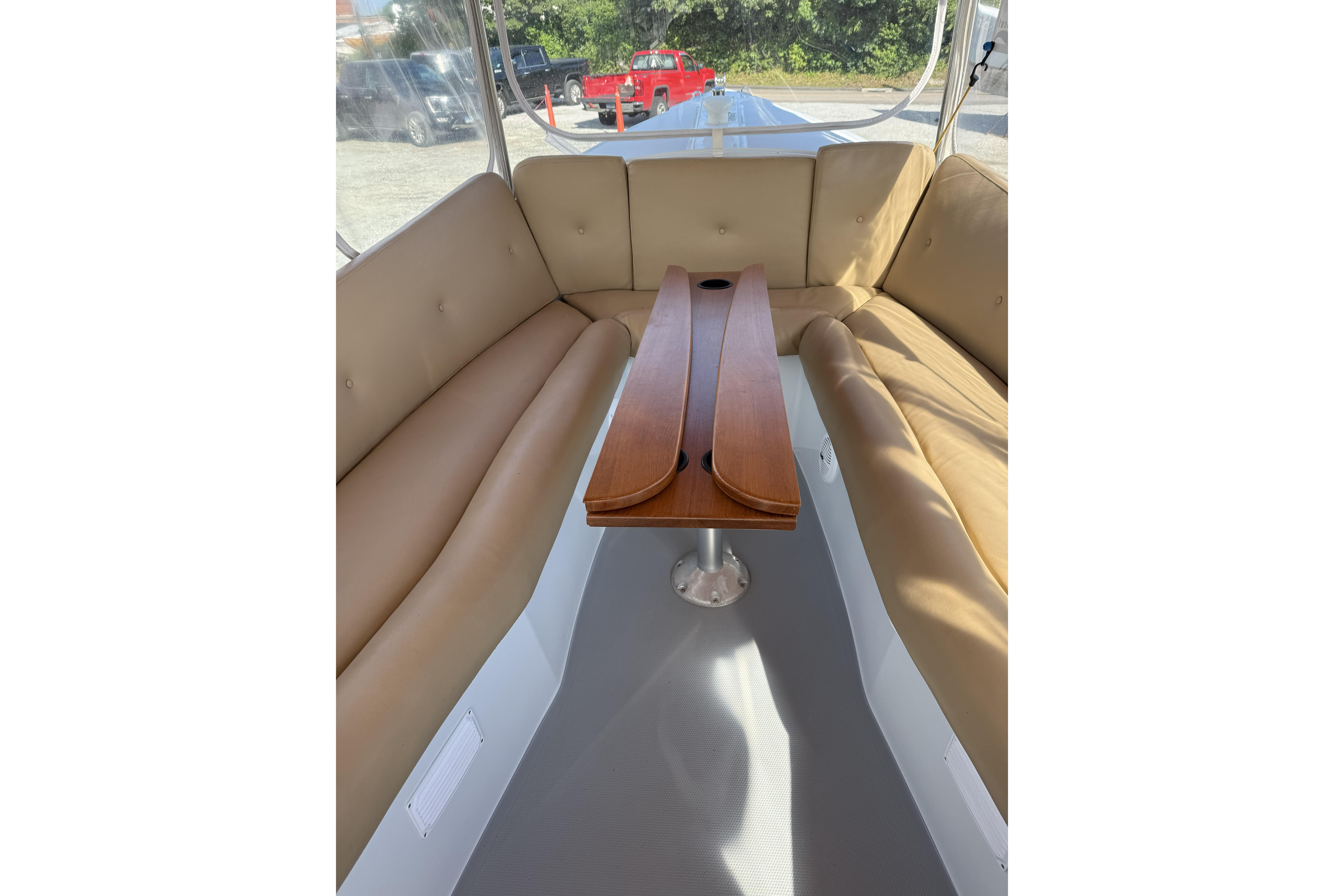 Interior of a 2004 Duffy 21 Classic boat with tan seating and wooden table.
