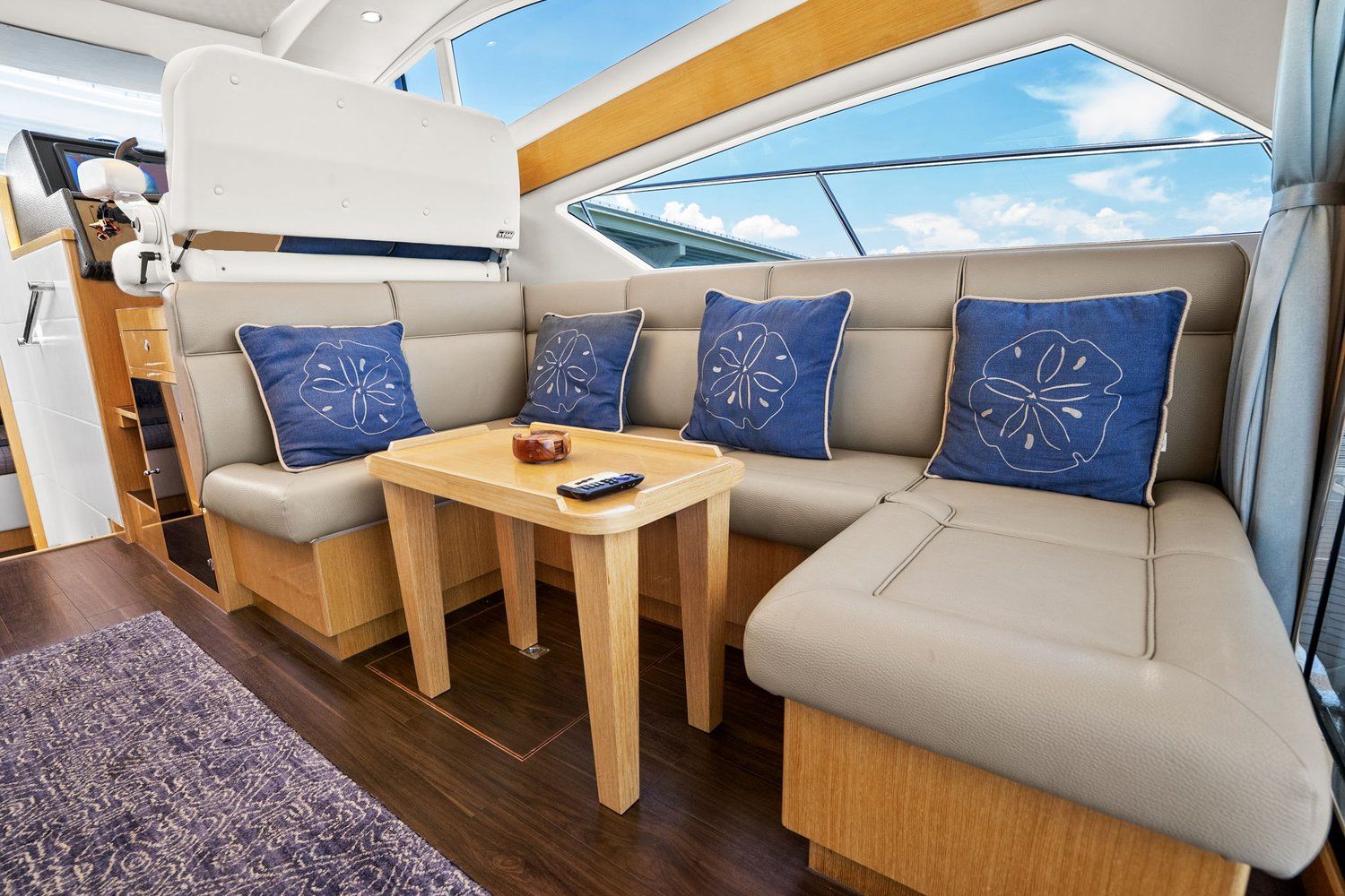Interior of a luxurious catamaran lounge with beige sofas and blue cushions.