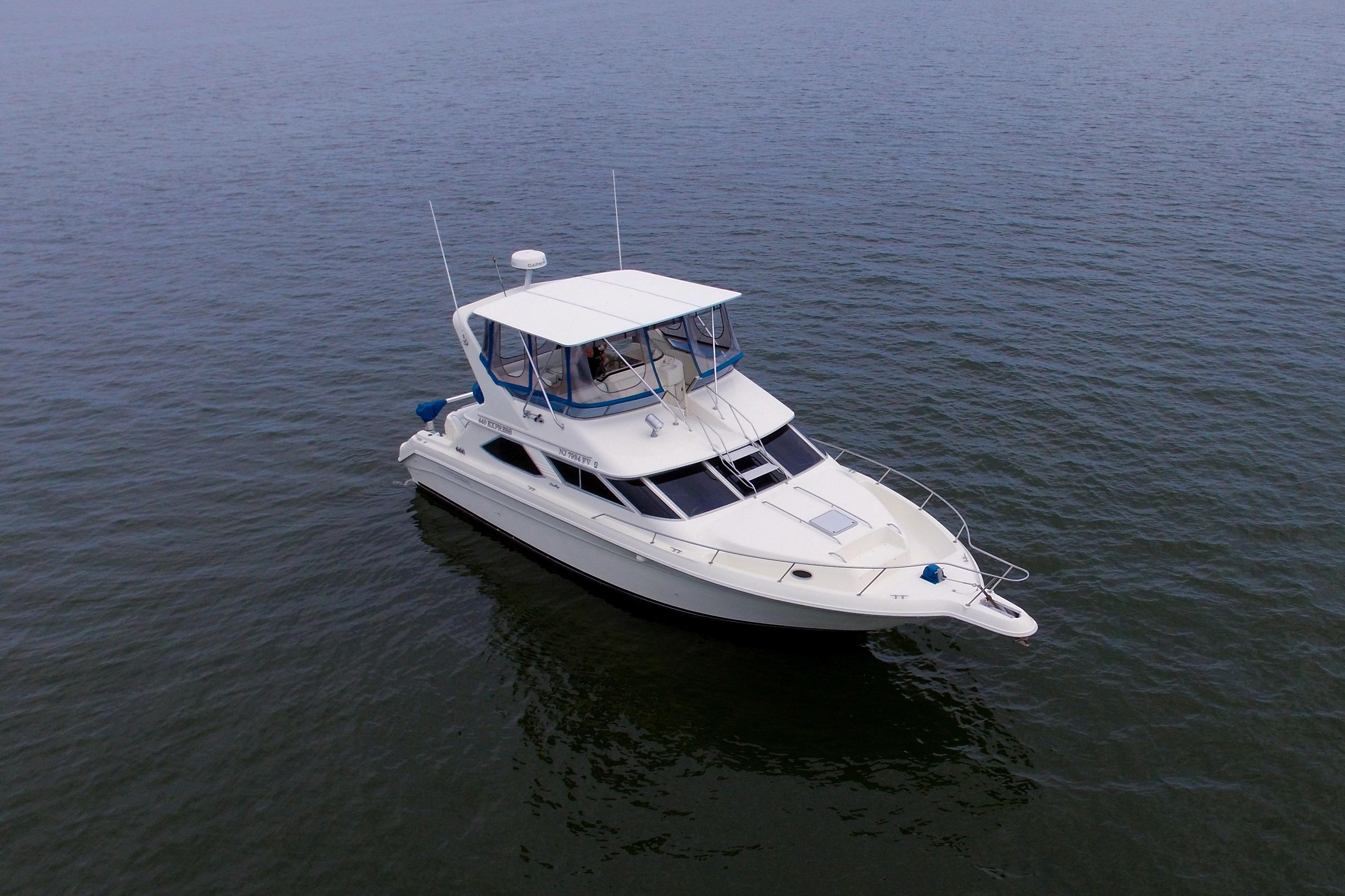 1993 Sea Ray 440 Express Bridge yacht on calm water, showcasing sleek design and spacious deck.