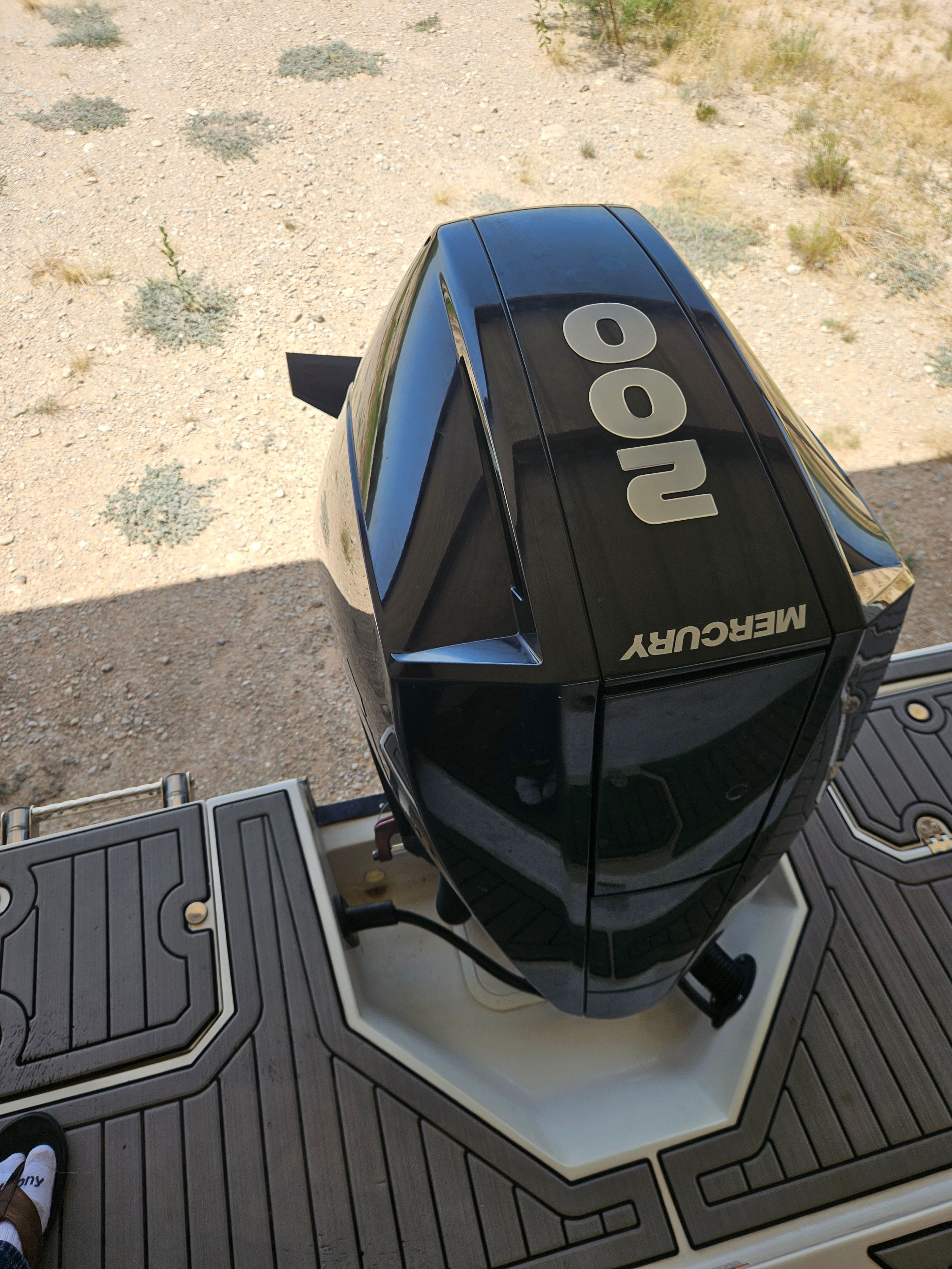 A Mercury outboard motor on a boat, situated on dry land.