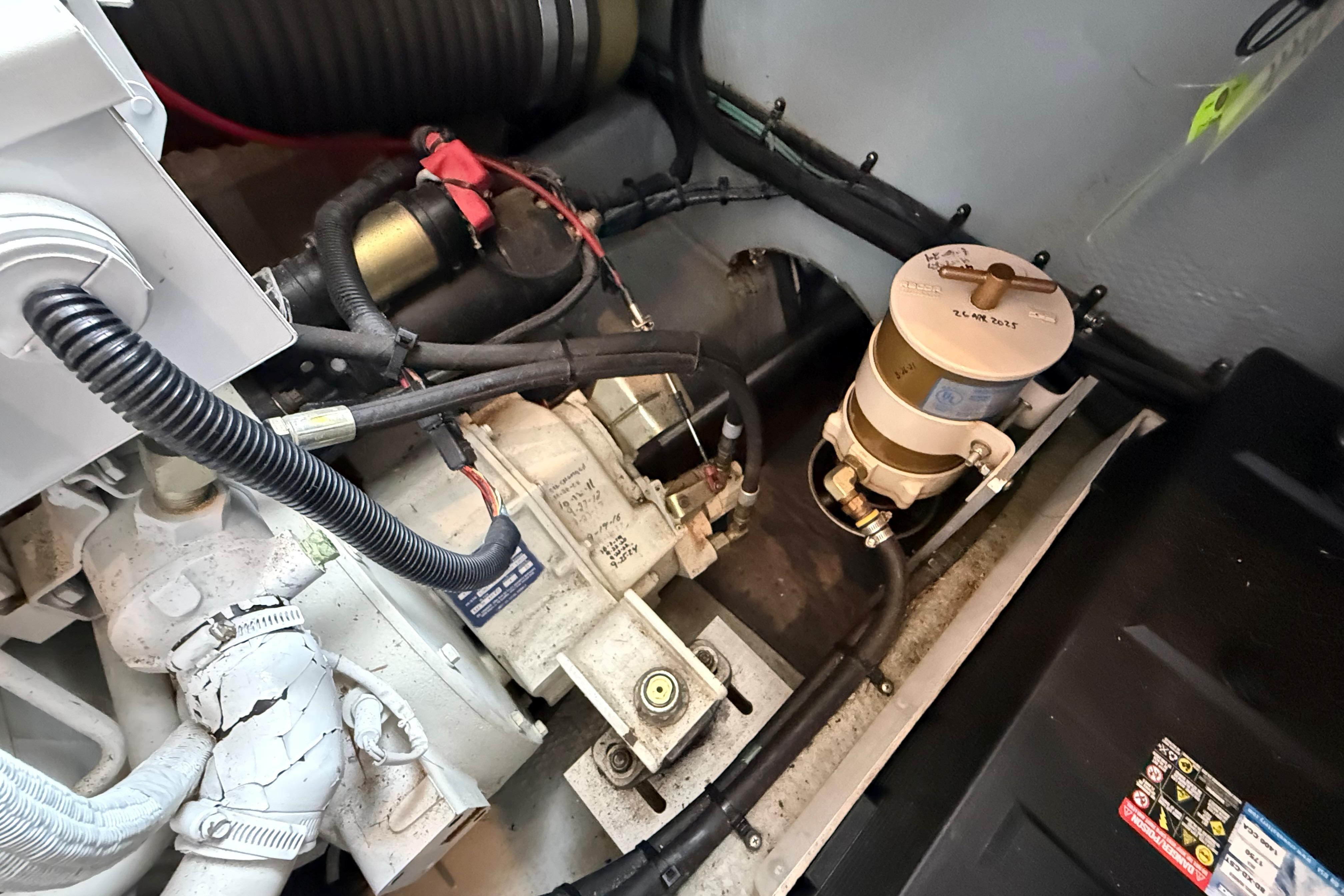 Engine compartment of a 1999 Mainship 350 Trawler, showcasing mechanical components and wiring.