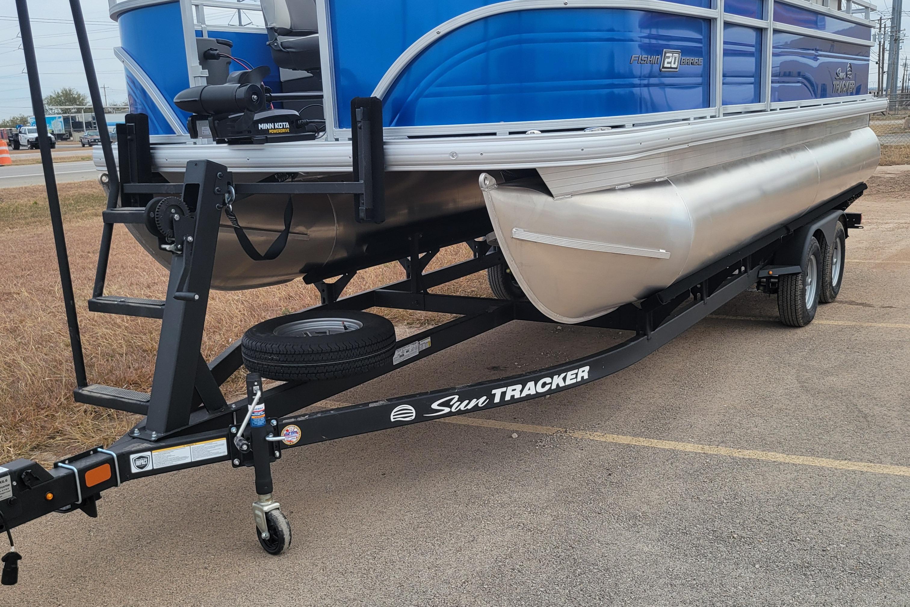 2026 Sun Tracker Fishin' Barge 20 DLX on trailer, blue and silver design.