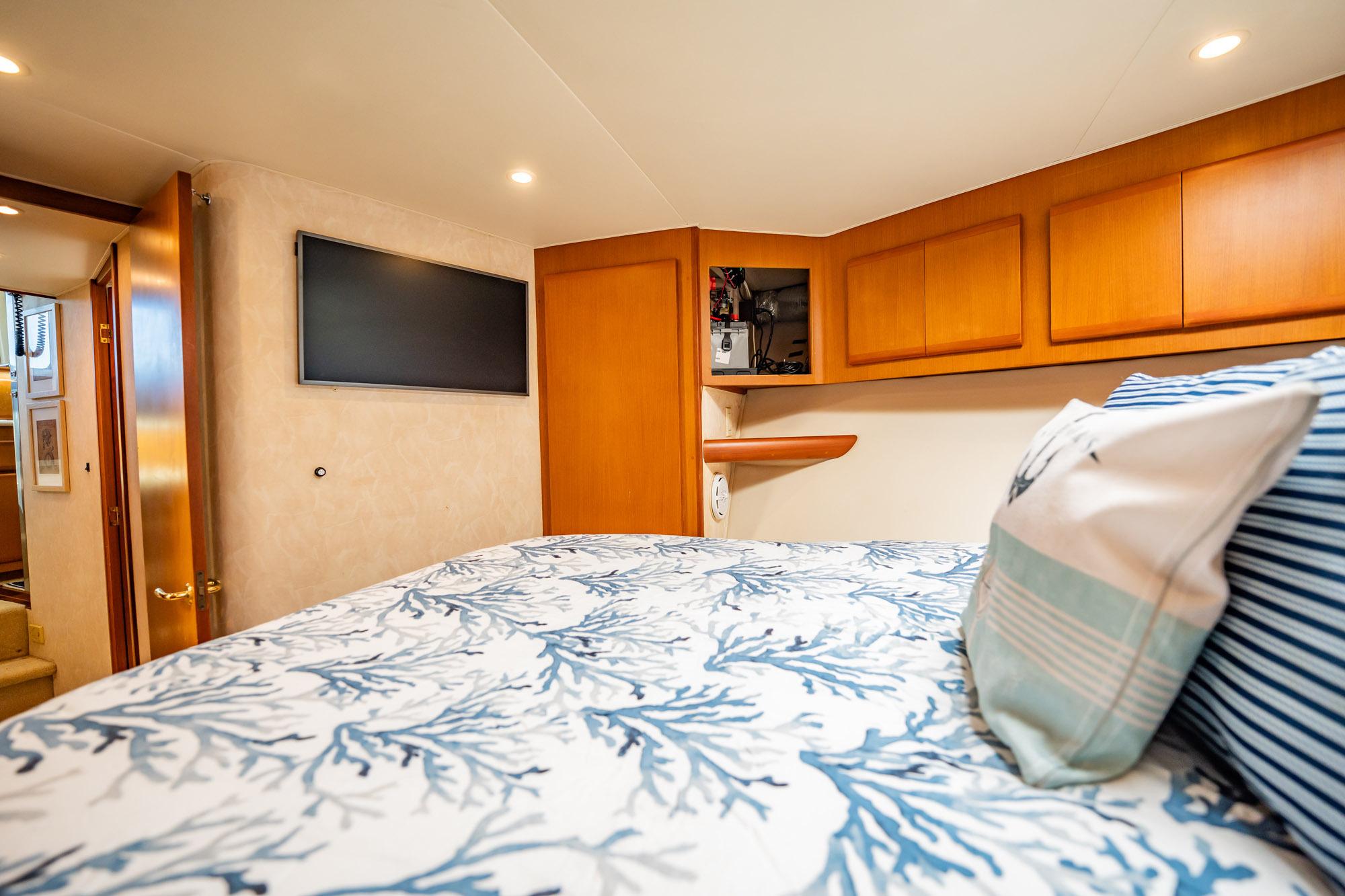 Luxurious cabin interior of 2001 Post 42 yacht with cozy bedding and modern amenities.