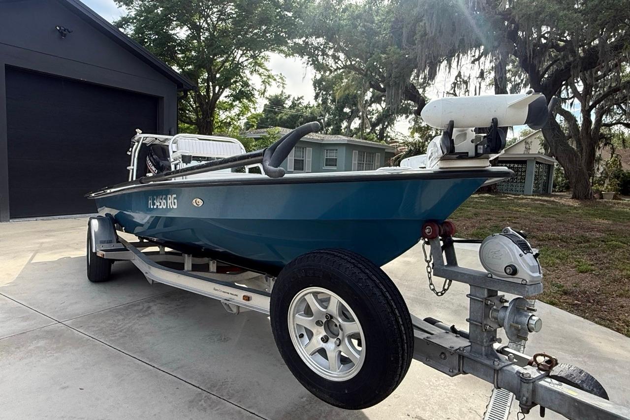 2017 East Cape Vantage boat on trailer in driveway, surrounded by trees and houses.