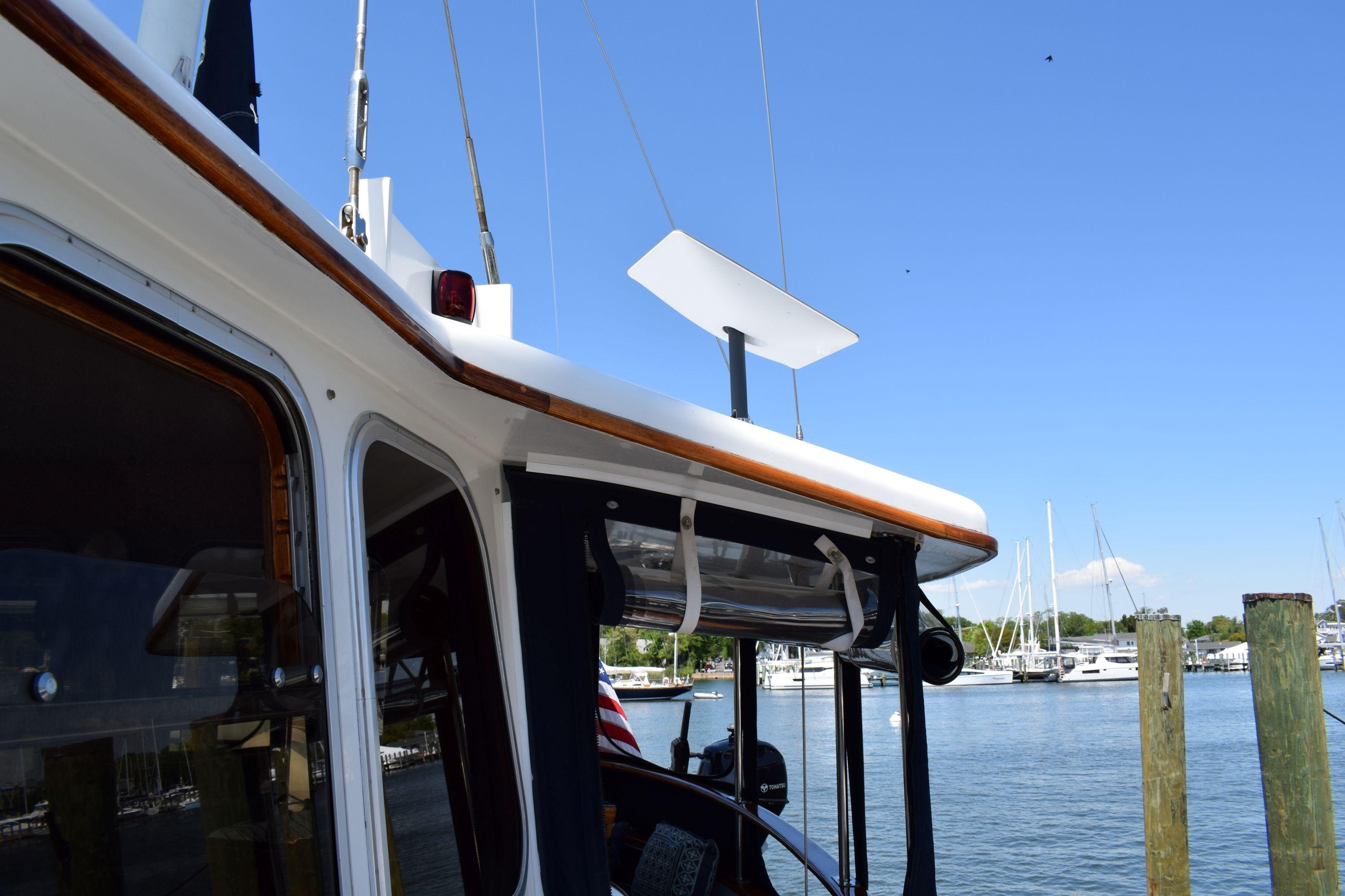1980 Cheoy Lee 52 Motorsailer docked, showcasing cabin and marina background.