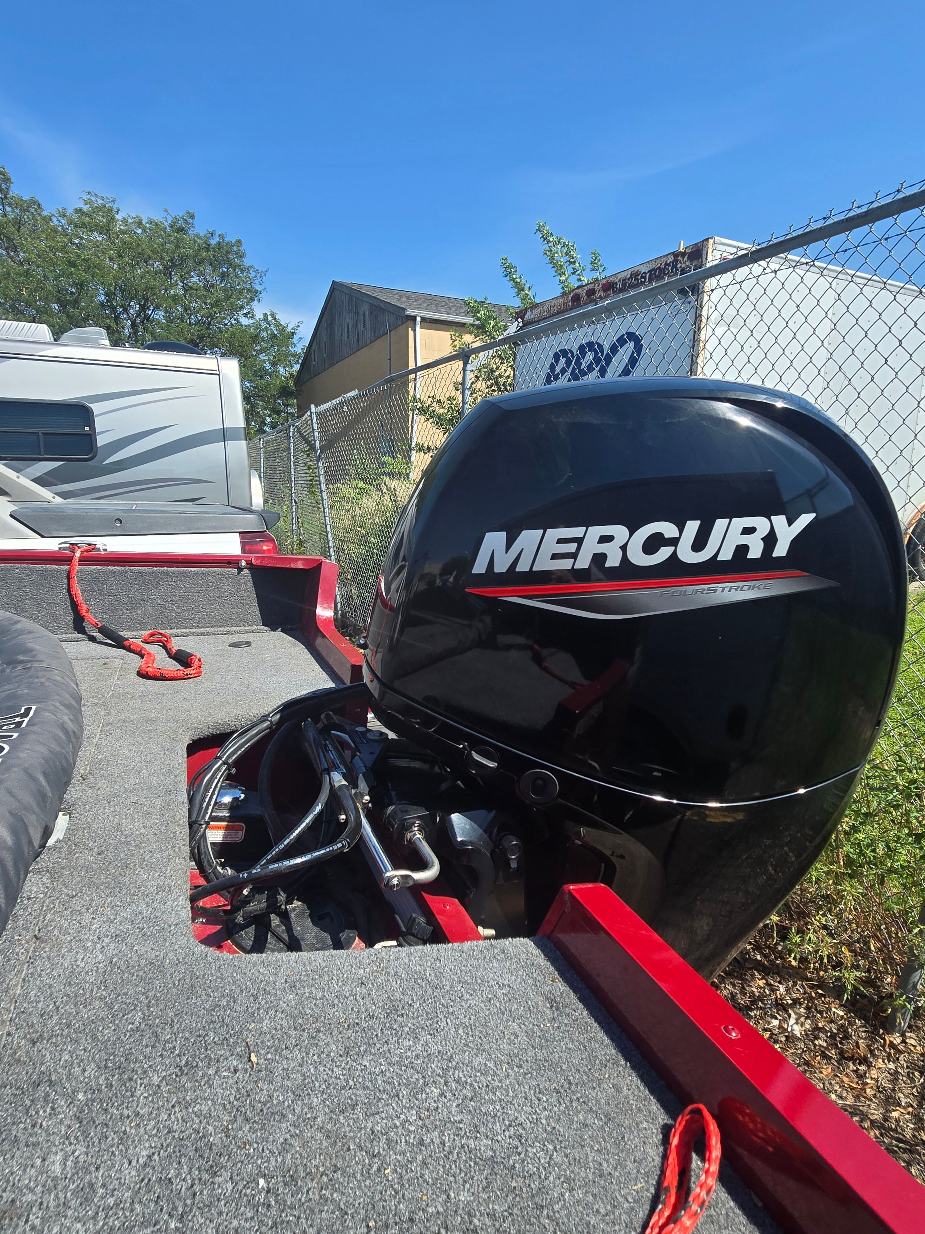 A Mercury outboard motor is mounted on a Bass Tracker PGV175 boat. The floor is carpeted in gray.