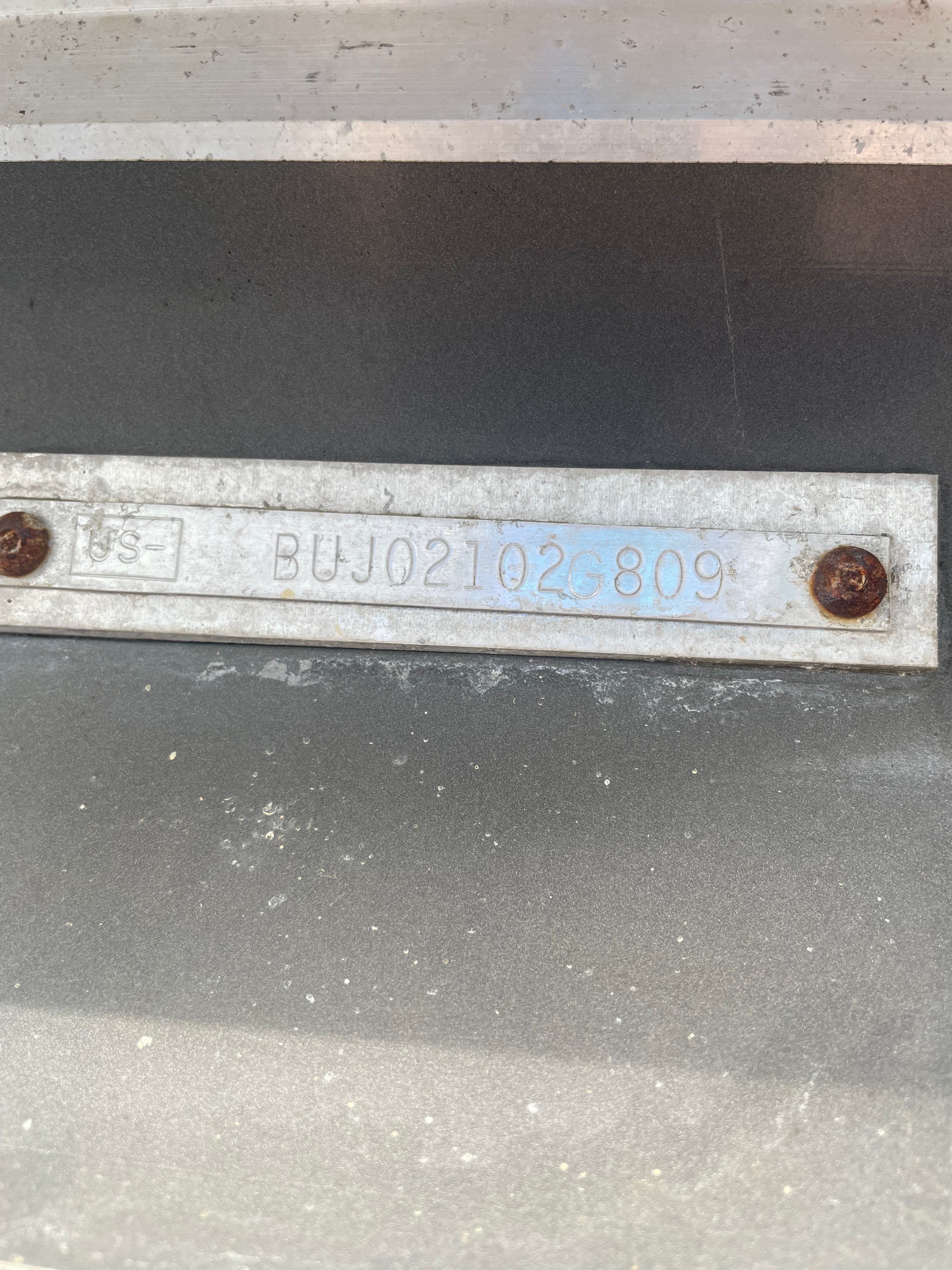 Close-up of a metal plate with an engraved serial number.