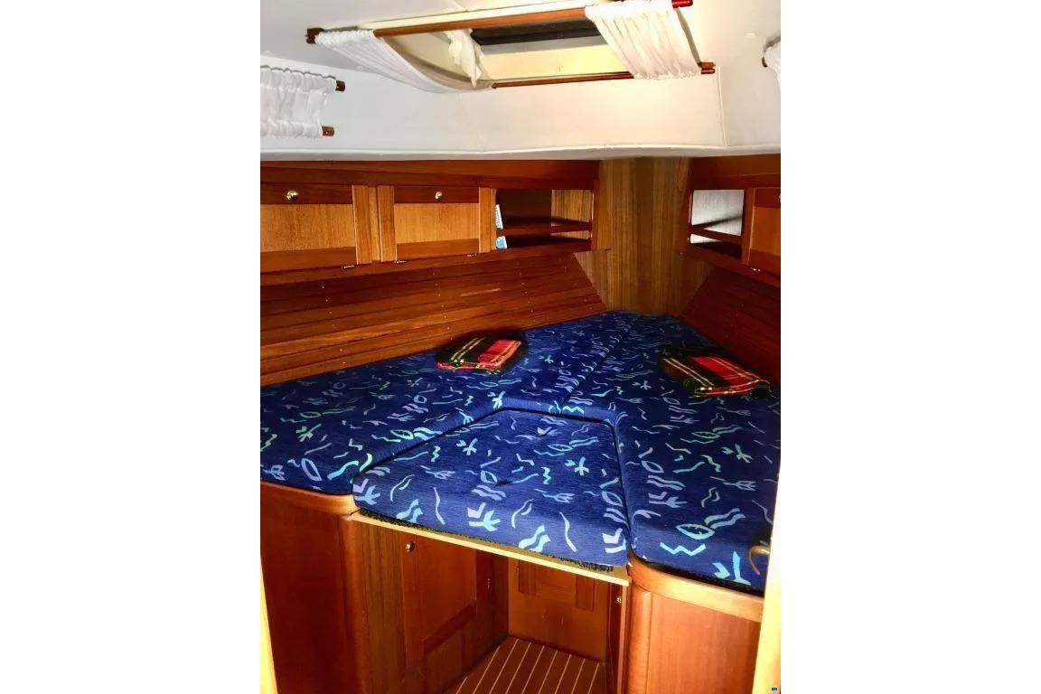 Cozy cabin interior of 1998 Nordship 35 DS sailboat with blue patterned bedding.