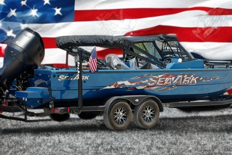 2025 SeaArk Protege 240 boat with American flag design, parked on a trailer.