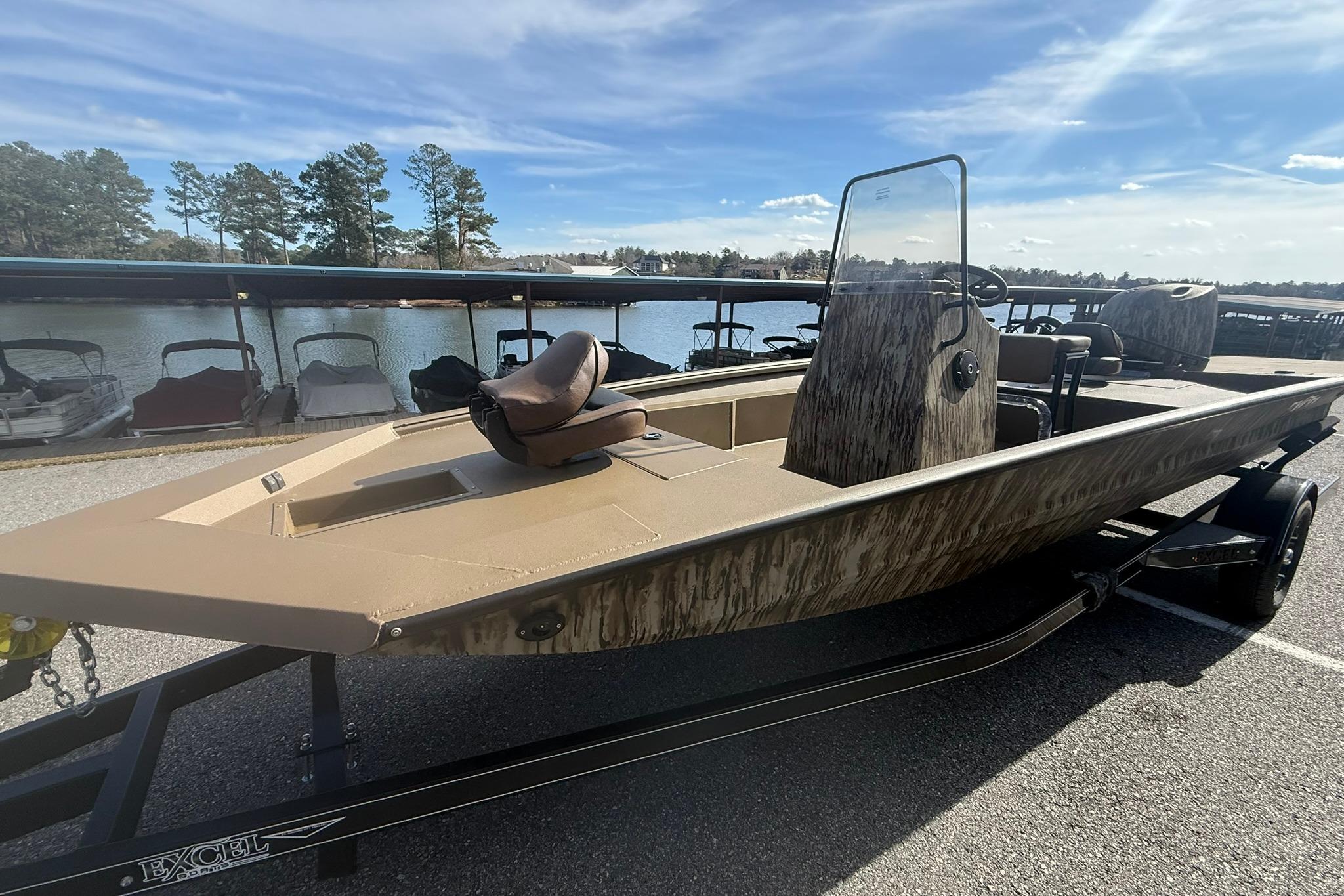 2026 Excel 206 Stalker CC boat on trailer by a lakeside dock.