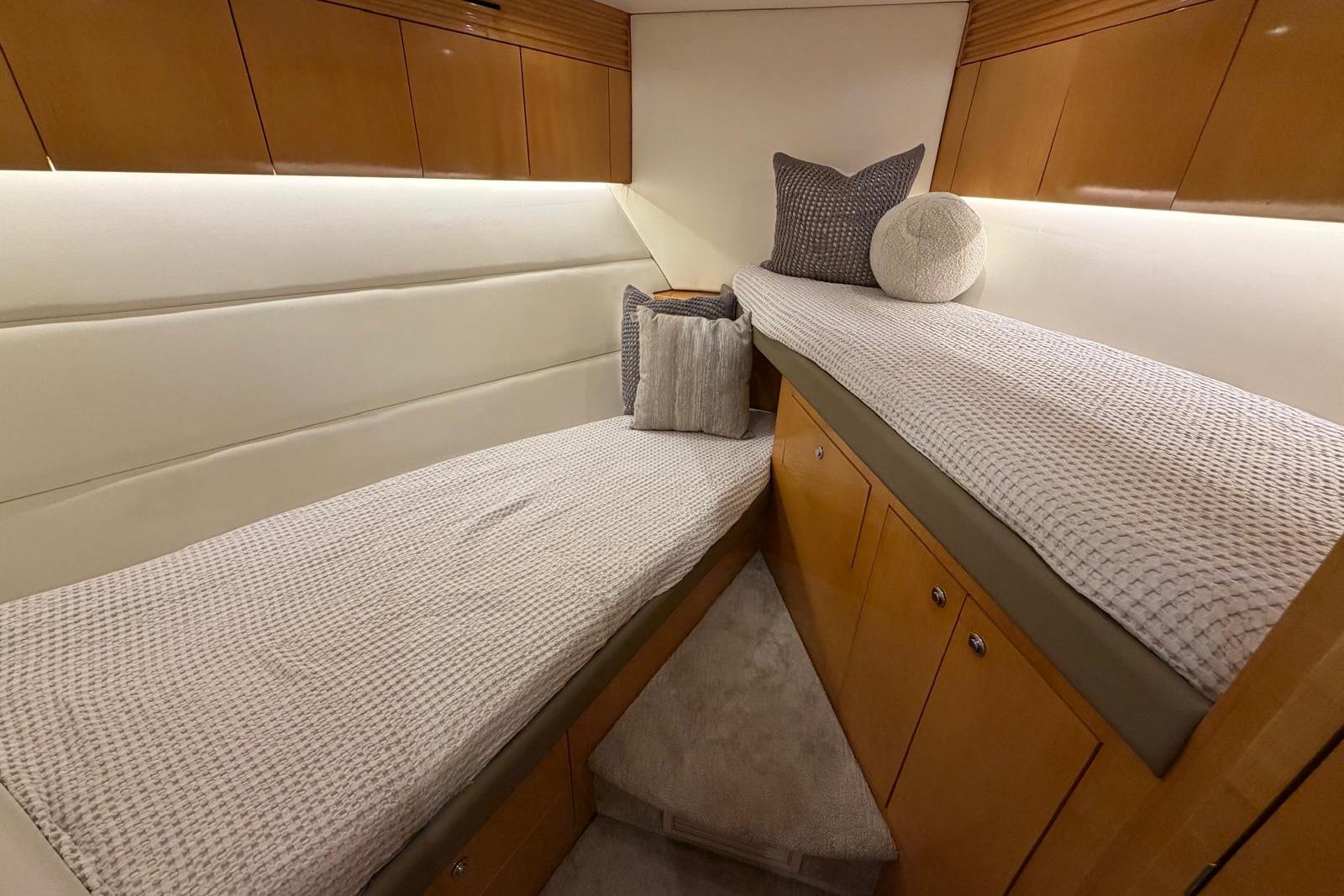 Interior cabin of 2003 Hatteras 54 Convertible yacht with twin beds and wooden cabinetry.