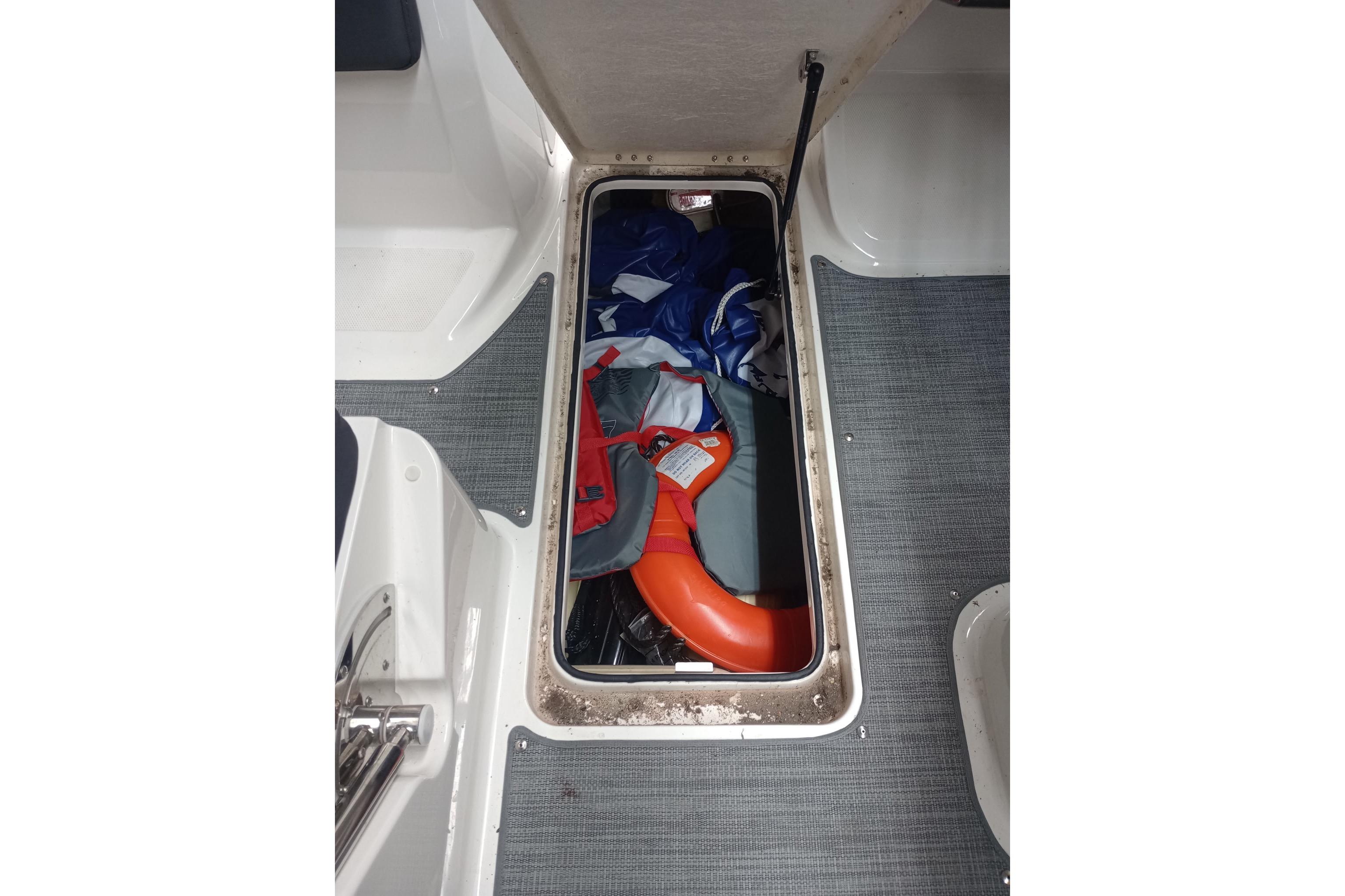 Storage compartment in 2022 Bayliner VR5 Bowrider I/O with life jacket and gear.
