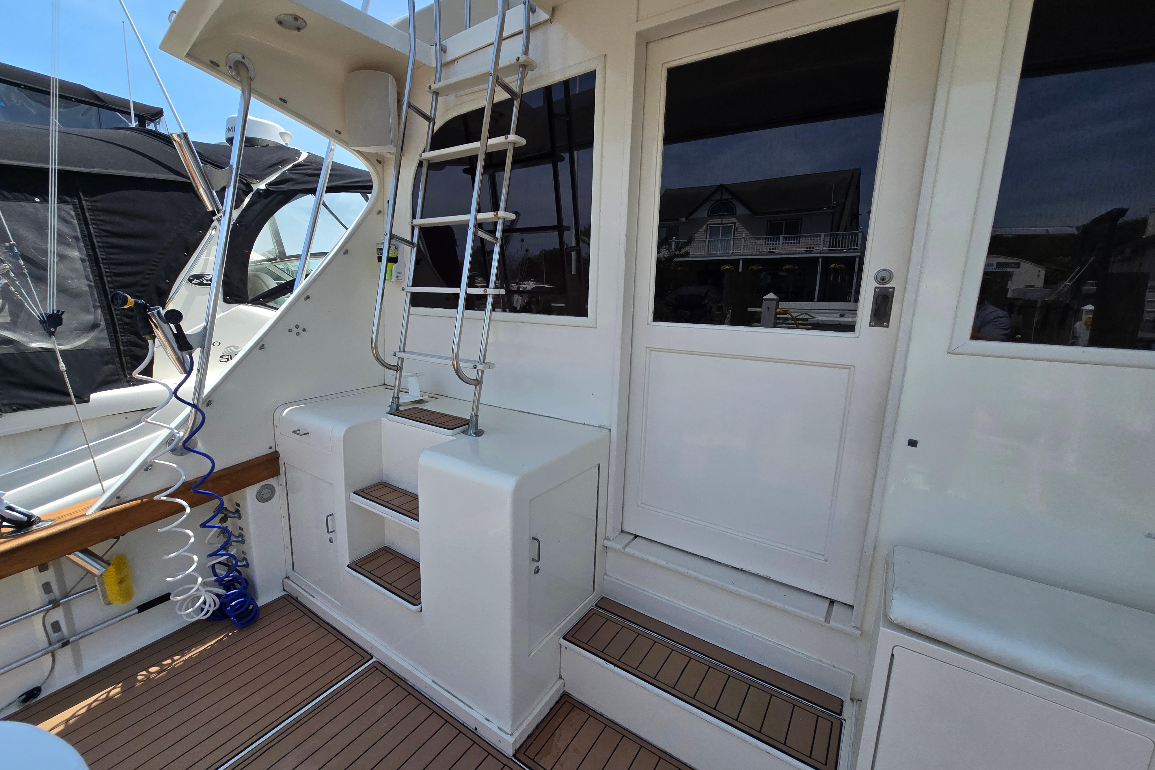 1988 Post 46 Convertible yacht deck with ladder and door, featuring teak flooring.