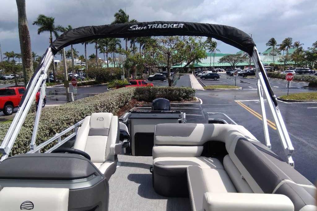 2026 Sun Tracker Fishin' Barge 22 DLX pontoon boat in a parking lot setting.