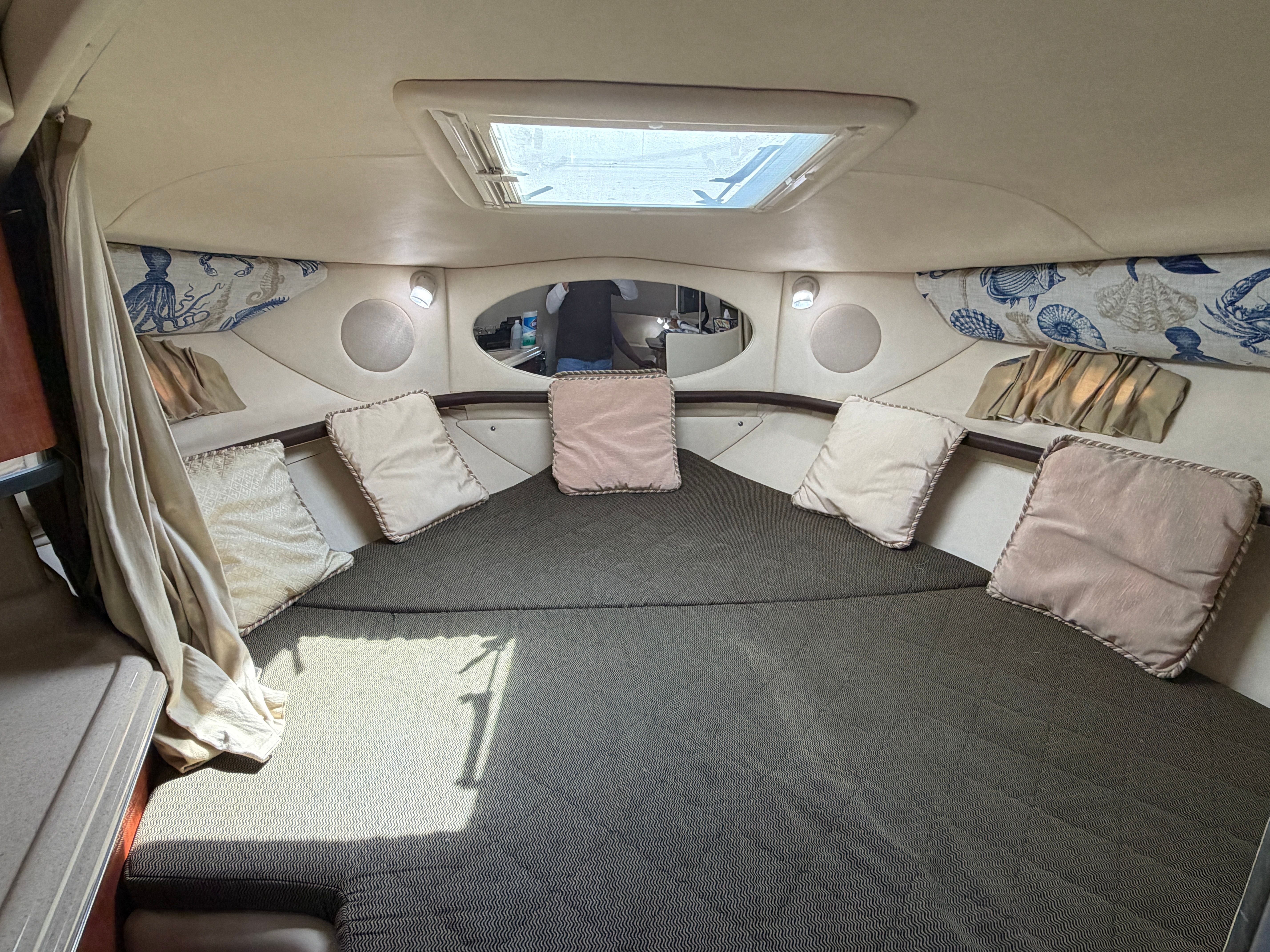 Interior of a 2005 Sea Ray 290 Amberjack with cushions and skylight.