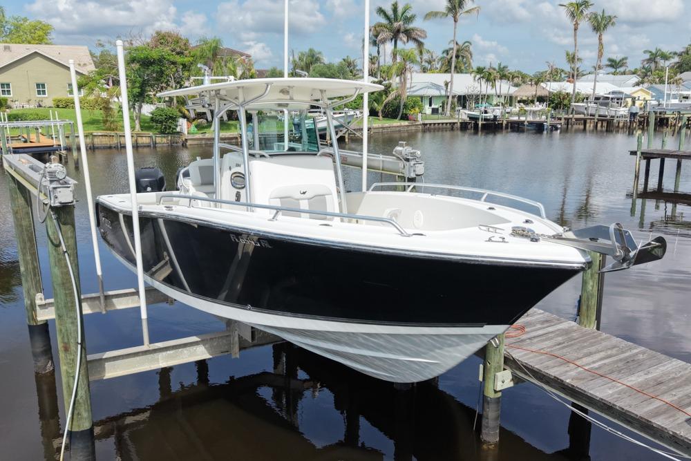 2018 Mako 284 Center Console boat docked by a scenic waterfront.