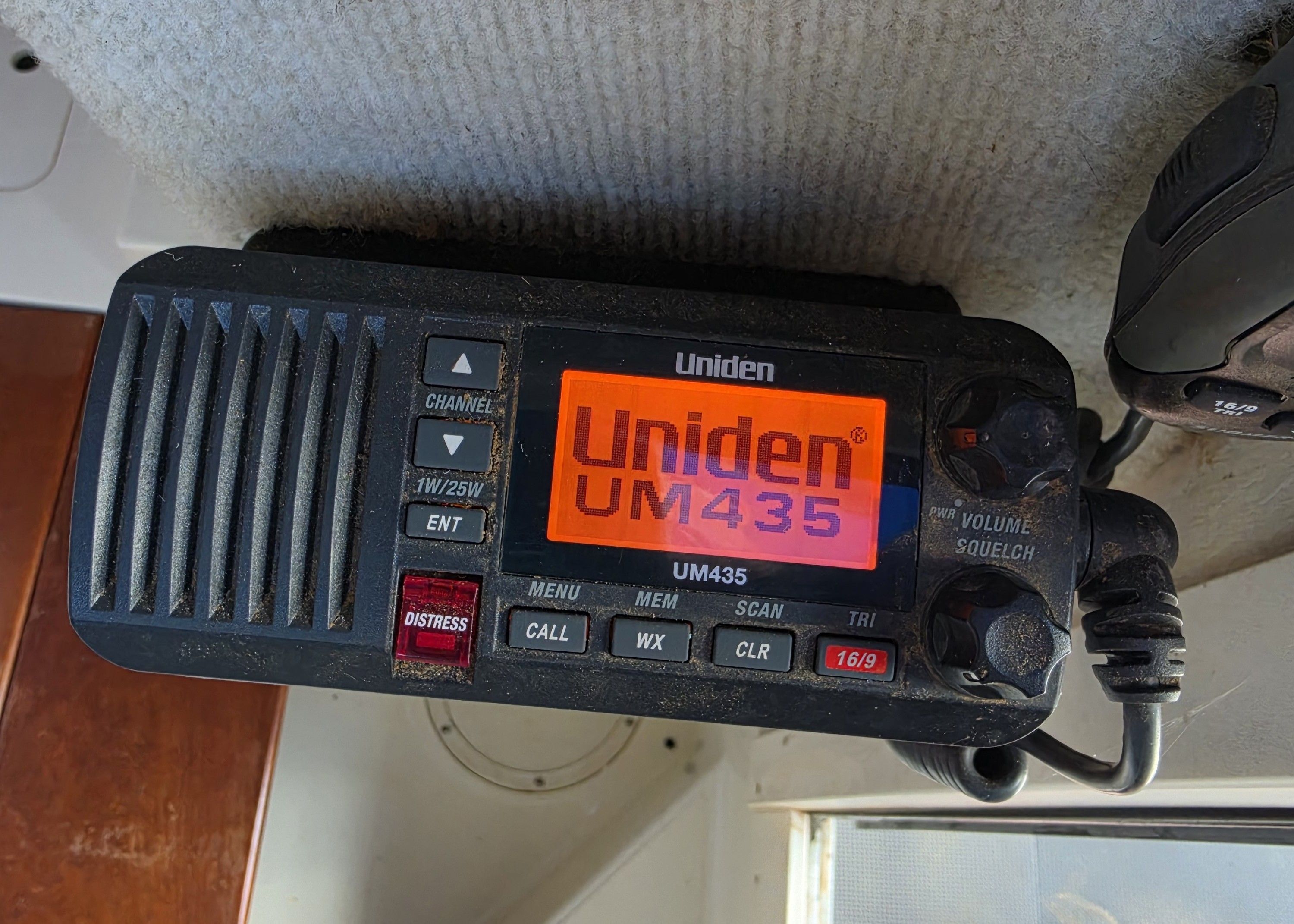 A Uniden UM435 radio is mounted on the ceiling of a boat.