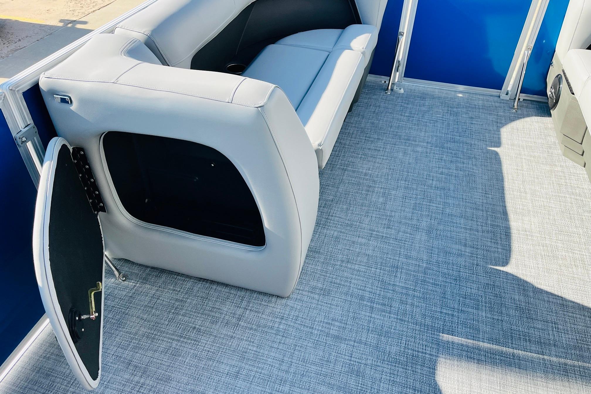 2026 Sun Tracker Party Barge 18 DLX interior with open storage compartment and seating.