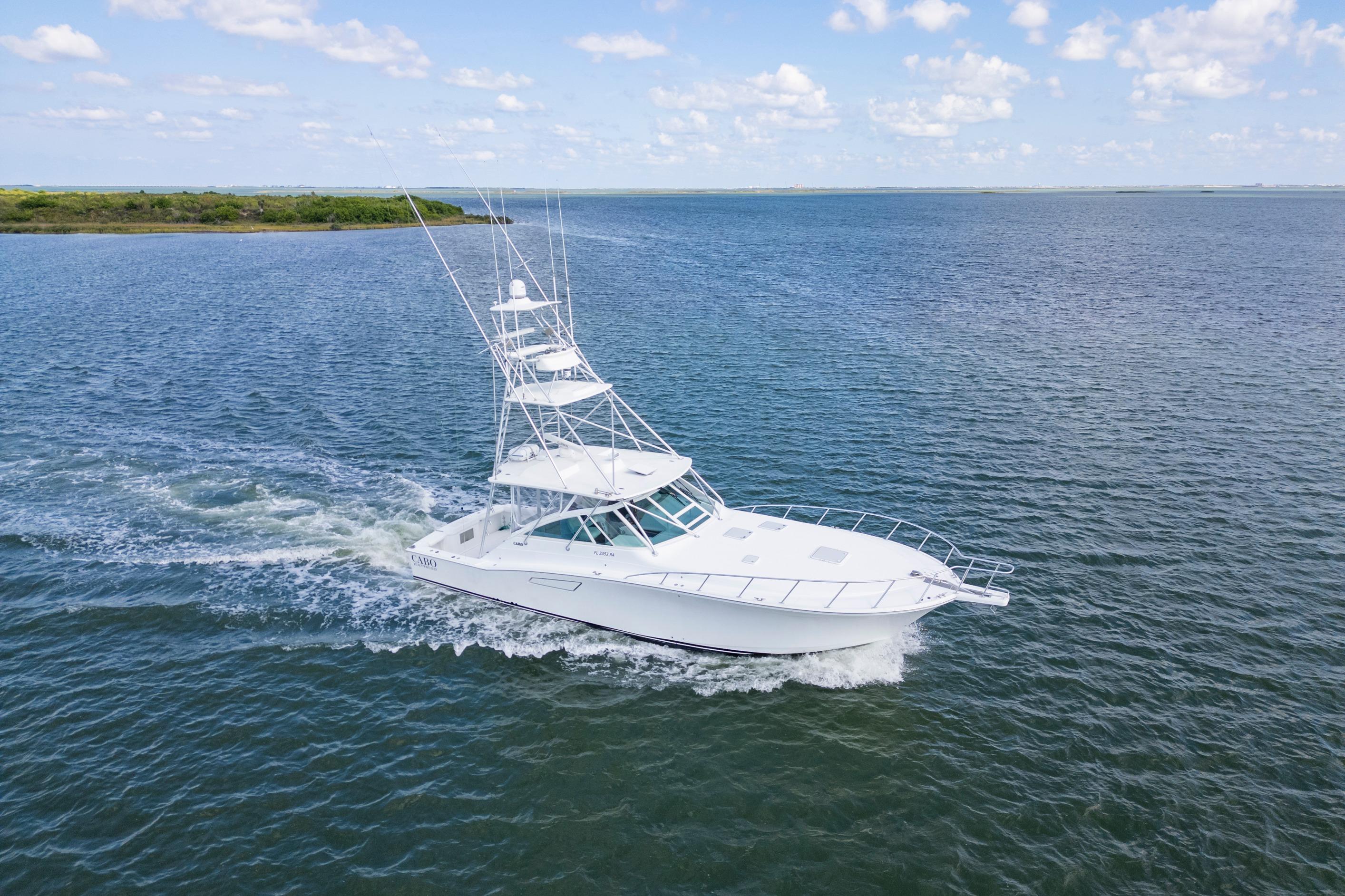 2010 Cabo 45 Express yacht cruising on open water under a clear sky.