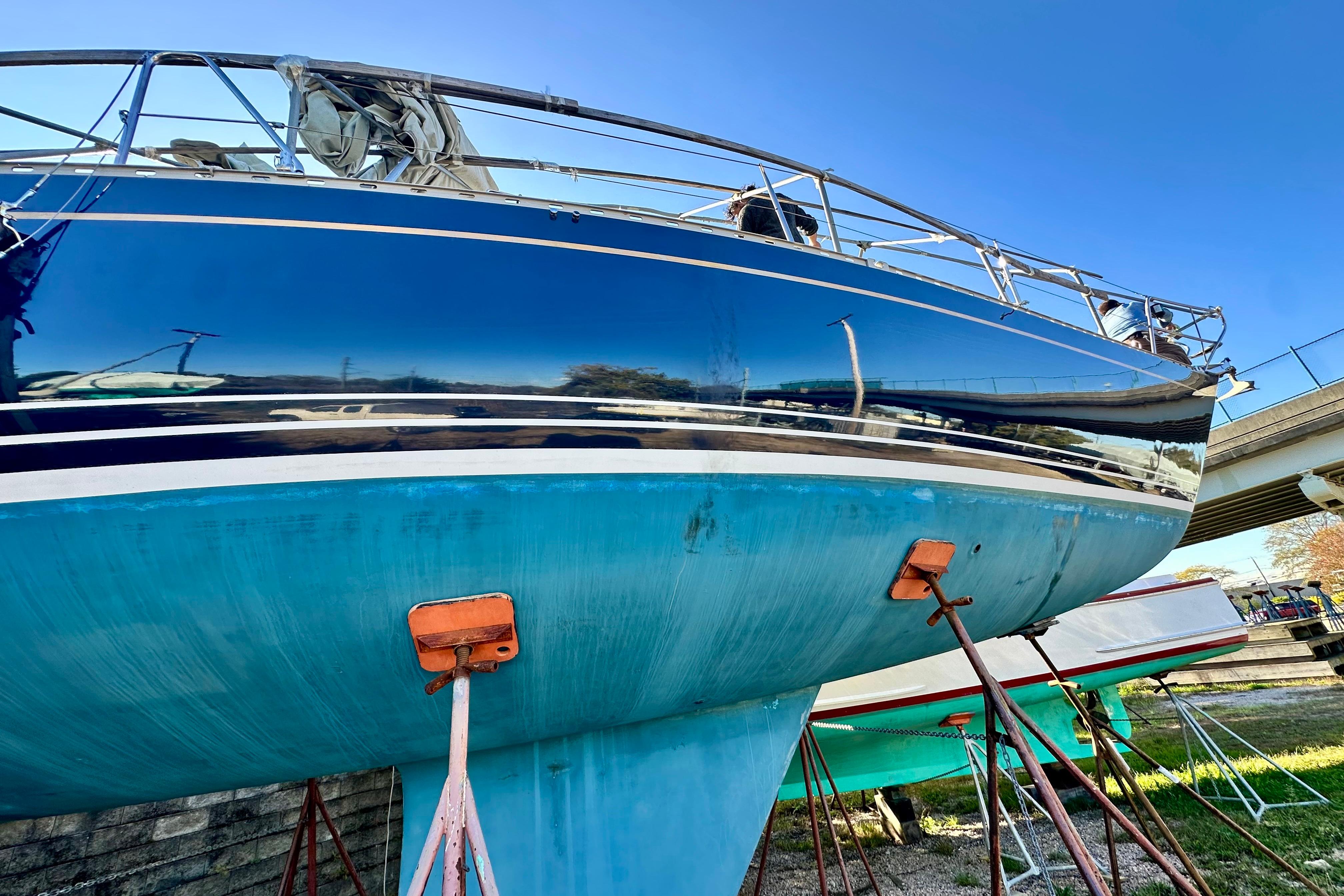 1984 Jonmeri 40 sailboat on stands, reflecting clear blue sky.
