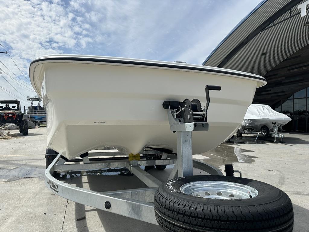 2024 Mako Pro Skiff 19 CC on trailer, parked outdoors under a partly cloudy sky.