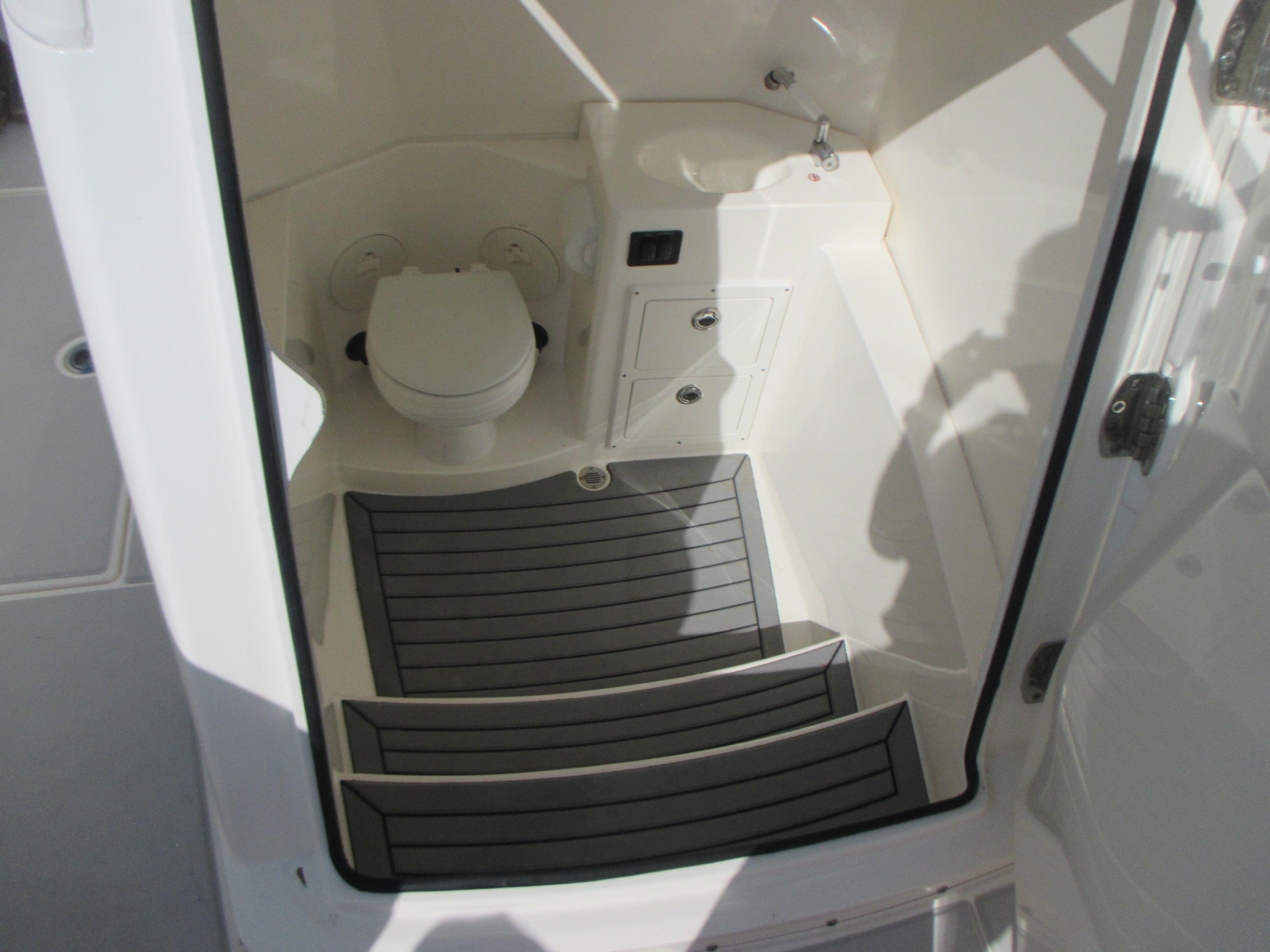 2018 Cobia 301 Center Console boat interior with toilet and sink.