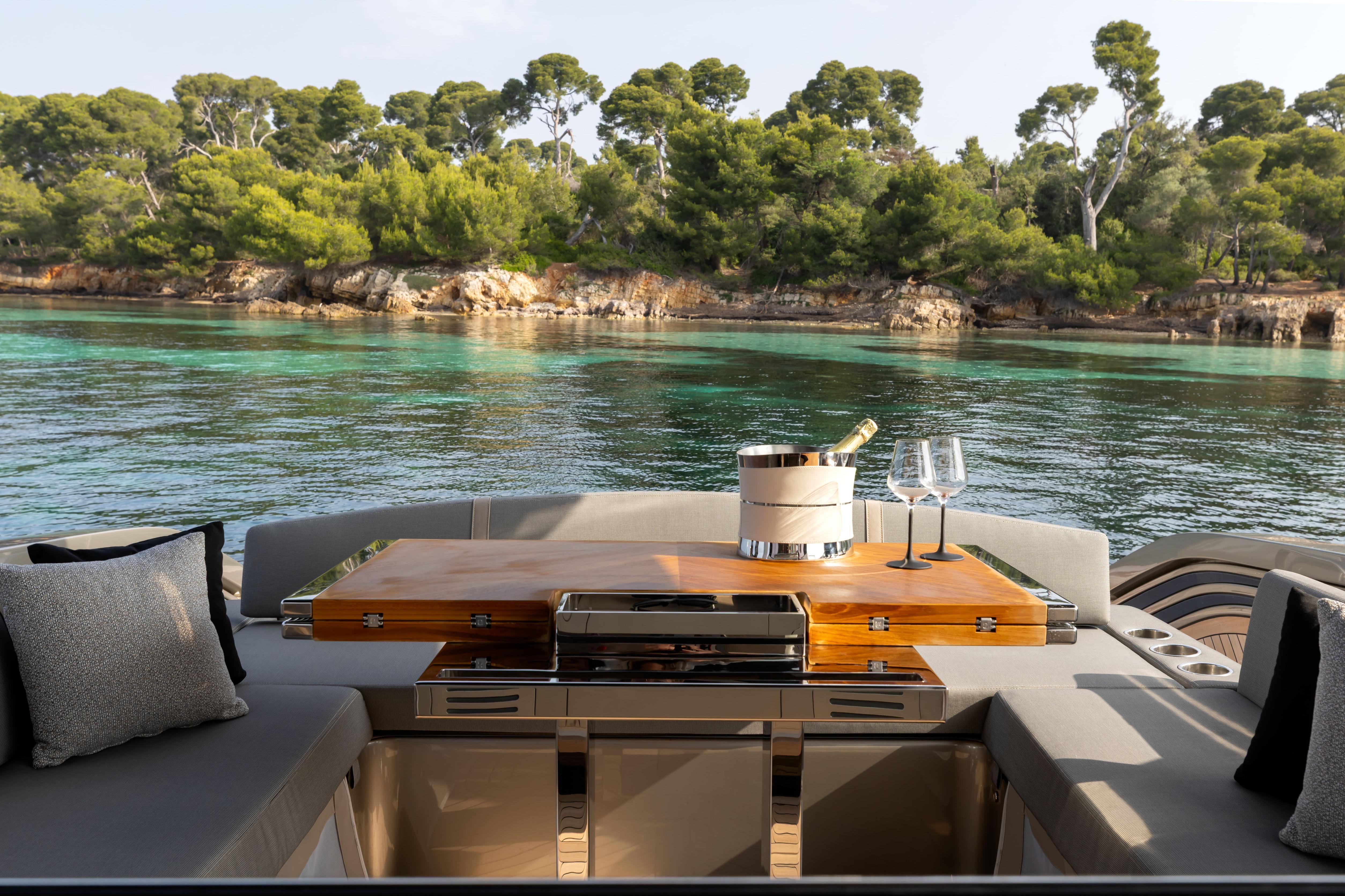 Luxurious FIM 500 Regina yacht interior with champagne, glasses, and scenic coastal view, 2025 model.