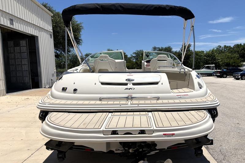 2007 Sea Ray 240 Sundeck boat with bimini top, parked outdoors.