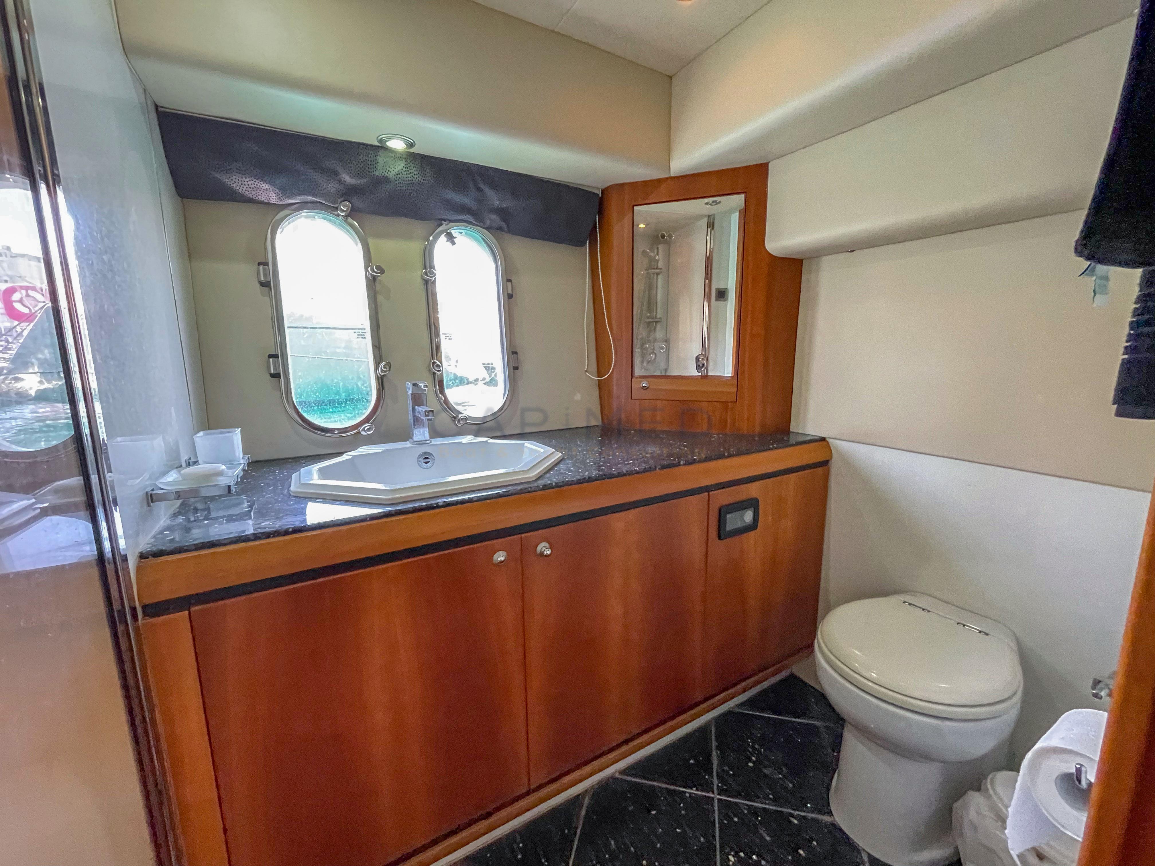Luxurious bathroom in 2006 Pearl 60 yacht with wooden cabinetry and modern fixtures.