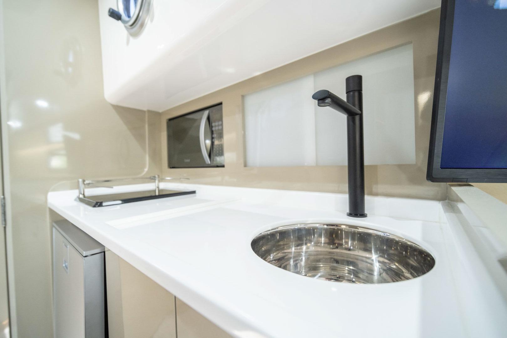 Modern kitchen area in 2026 Hanover 387, featuring sleek sink and microwave.