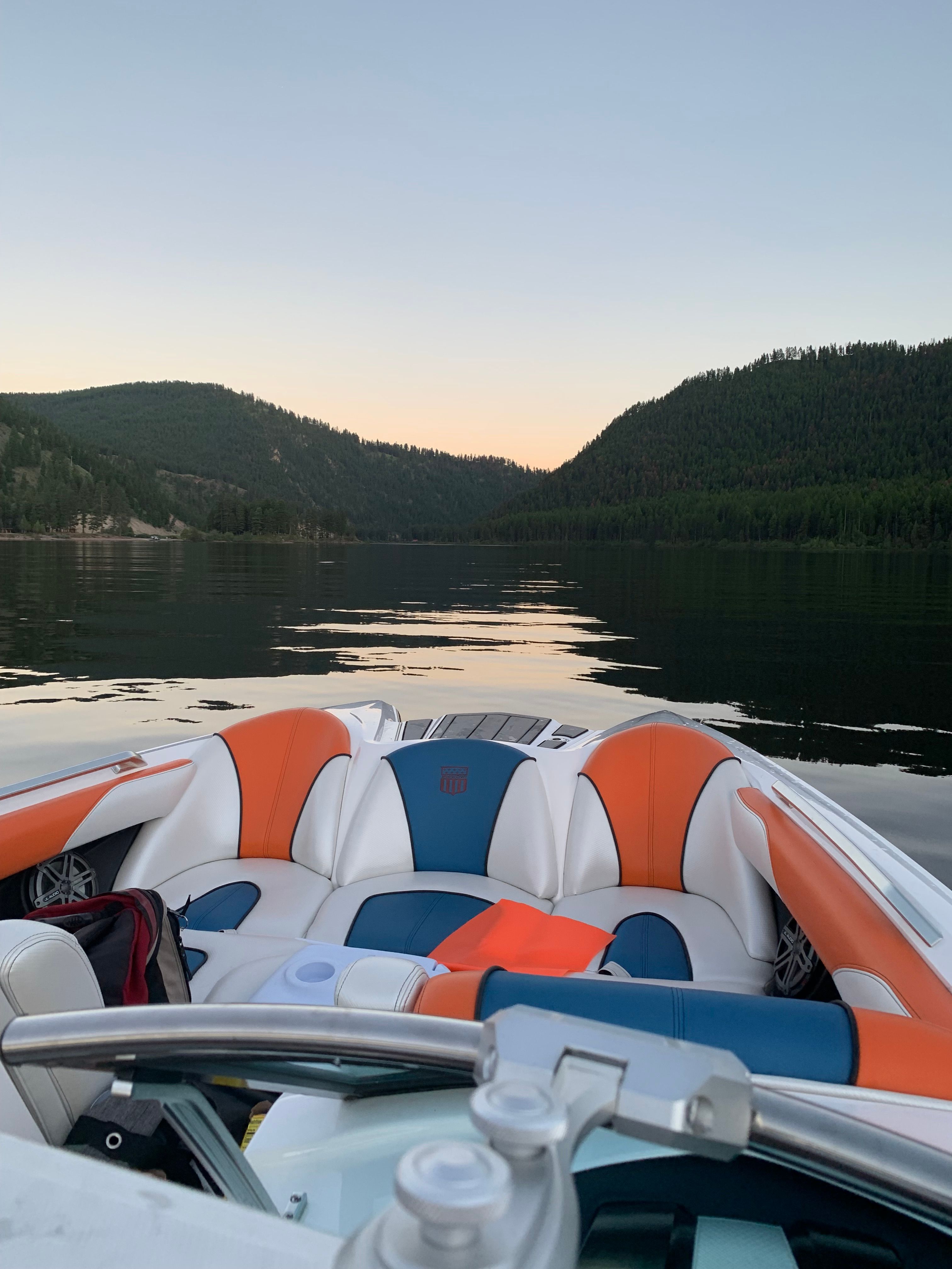 2013 MasterCraft XStar on a tranquil lake at sunset.