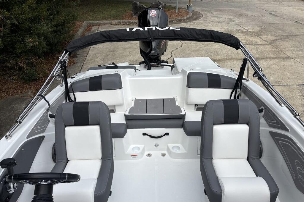 2026 Tahoe T21 boat interior with gray and white seating, steering wheel, and motor.
