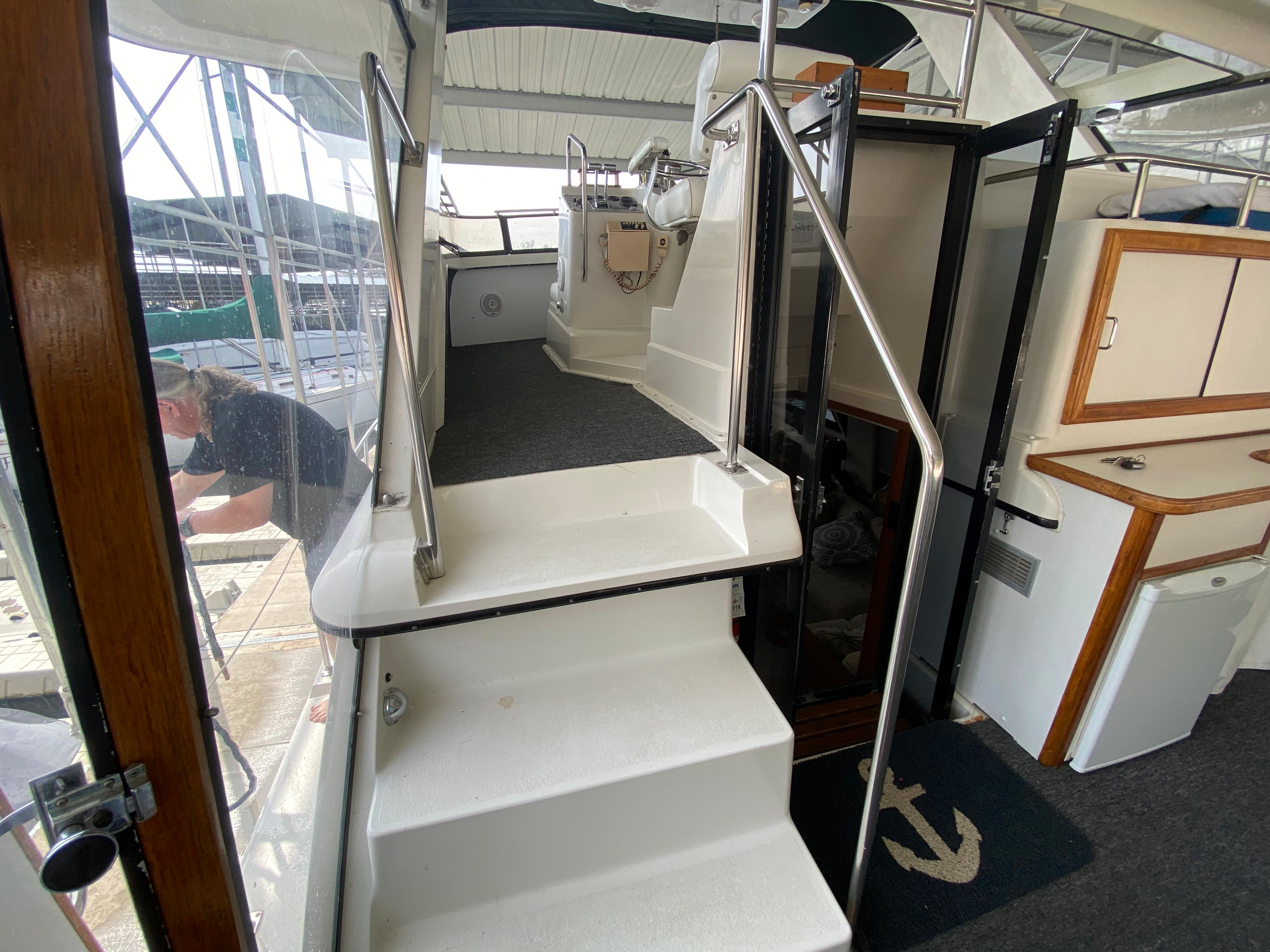1986 Carver 4207MY yacht interior with stairs leading to the helm station.