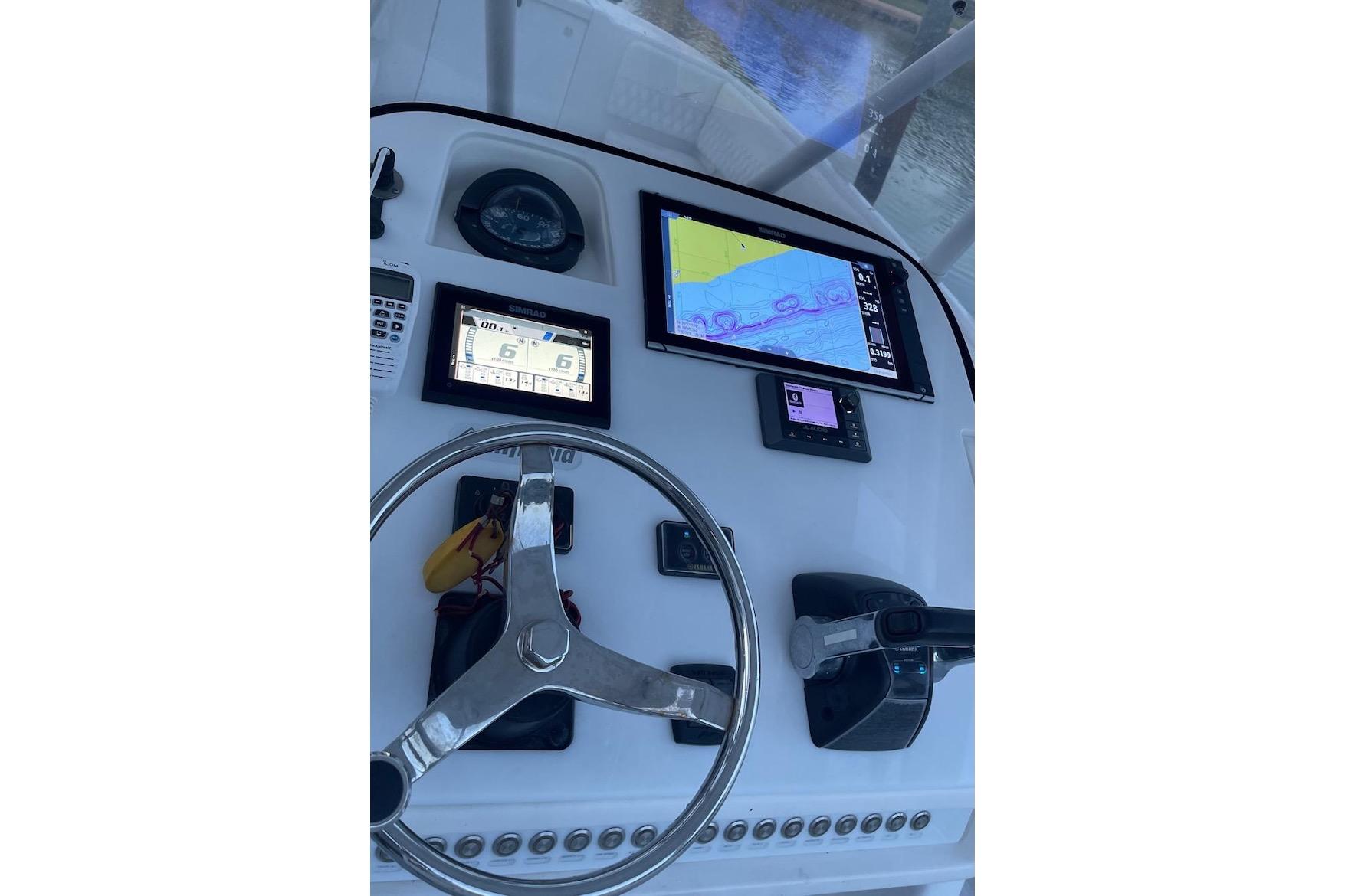 Helm of 2002 Intrepid 323 Cuddy with navigation screens and steering wheel.