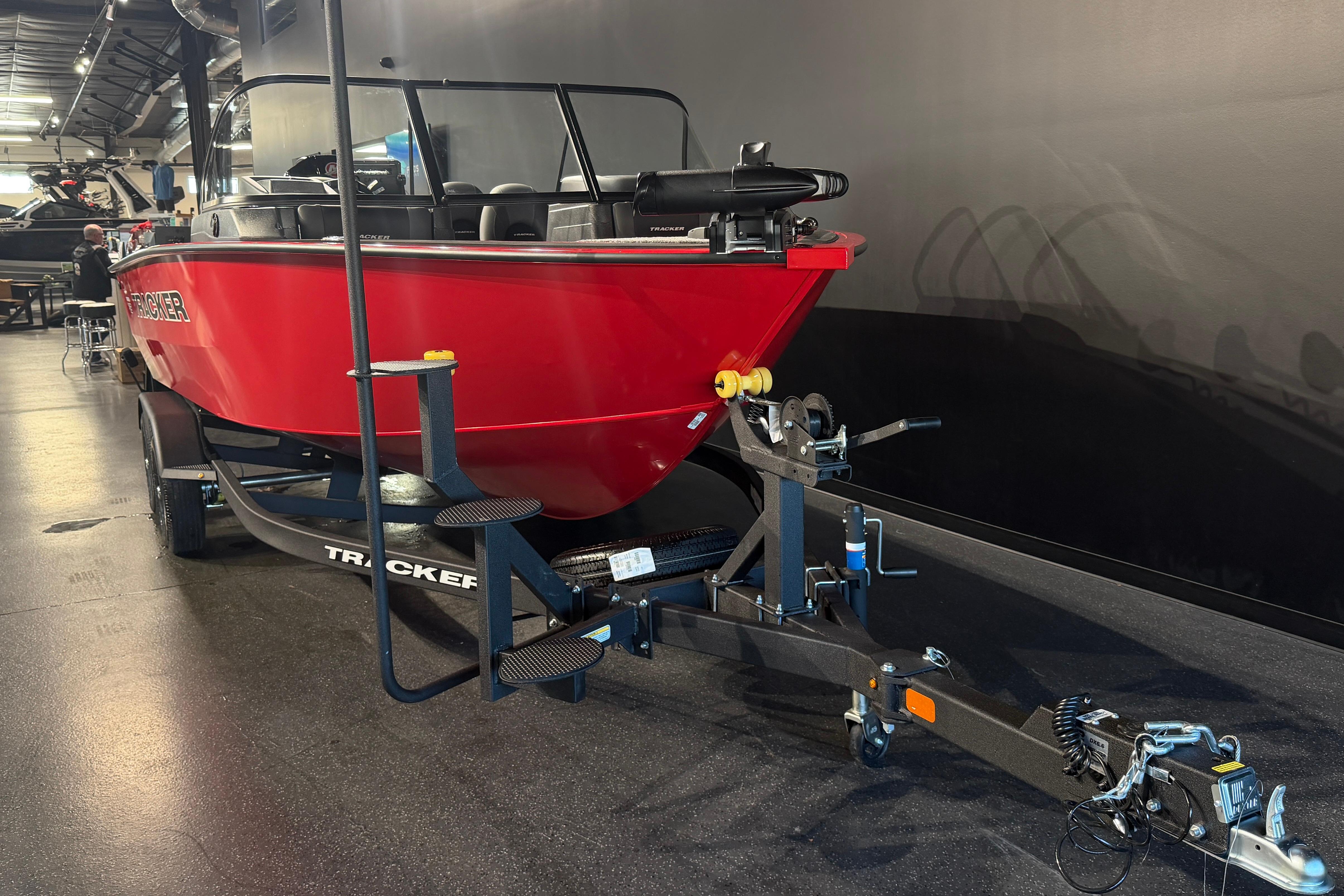 2026 Tracker Targa V-18 Combo boat in showroom, red hull, on trailer.