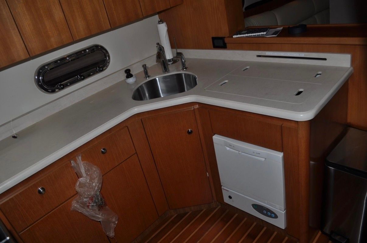 Galley of the 2005 Tiara Yachts 5200 Sovran with wood cabinets and stainless steel sink.