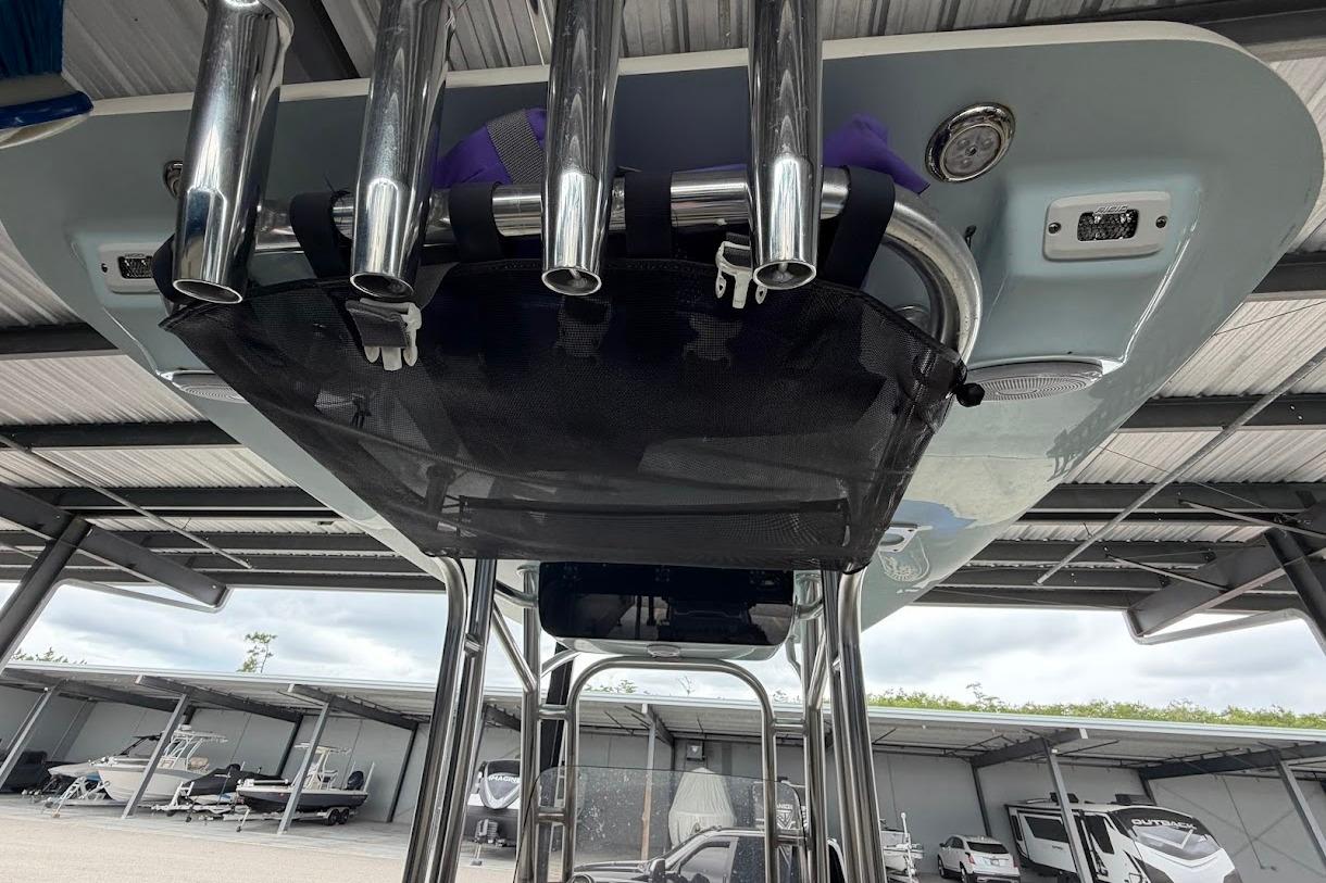 2024 Key West 219 FS boat with rod holders and storage net under a canopy.